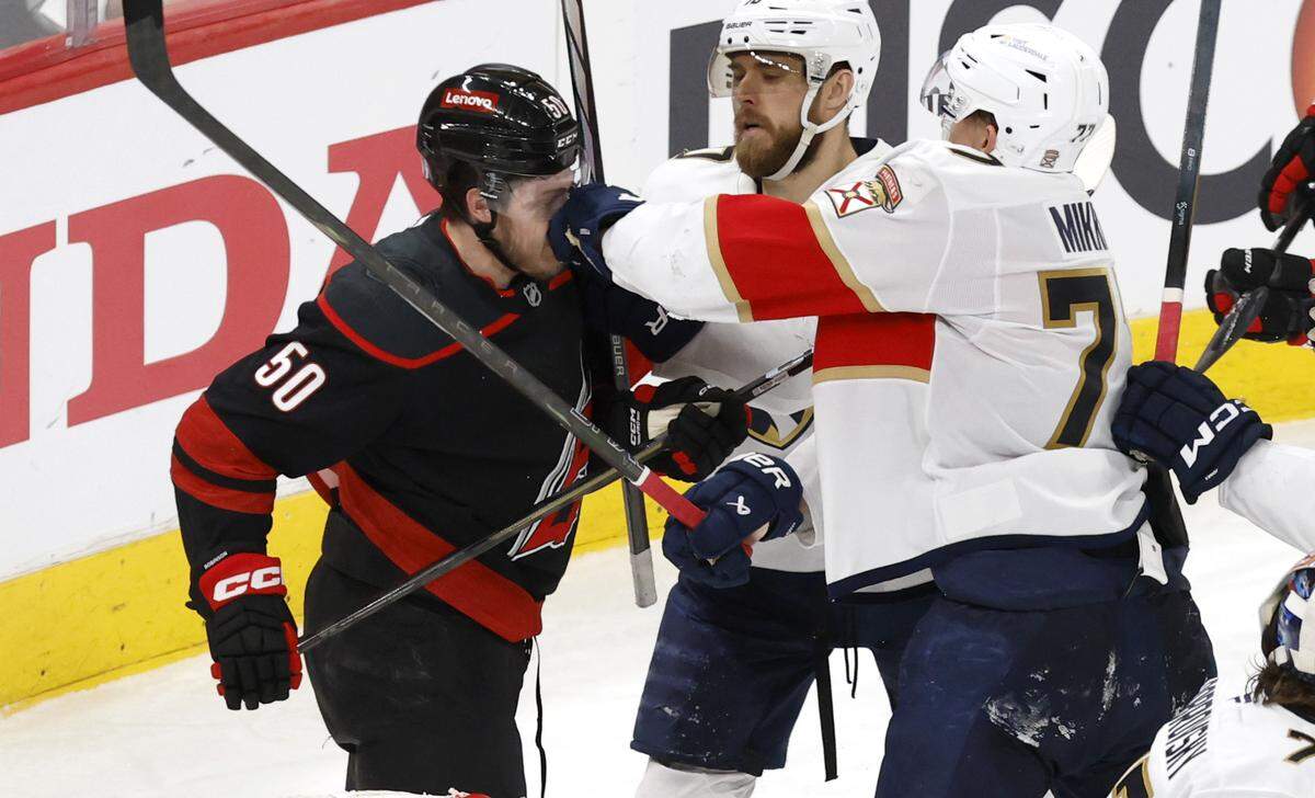 Panthers’ Niko Mikkola (77) hits Carolina’s Eric Robinson (50) as they scuffle during the third period of the Florida Panthers’ 5-0 victory over the Carolina Hurricanes in Game 2 of the Eastern Conference Final at the Lenovo Center in Raleigh, N.C., Thursday, May 22, 2025.