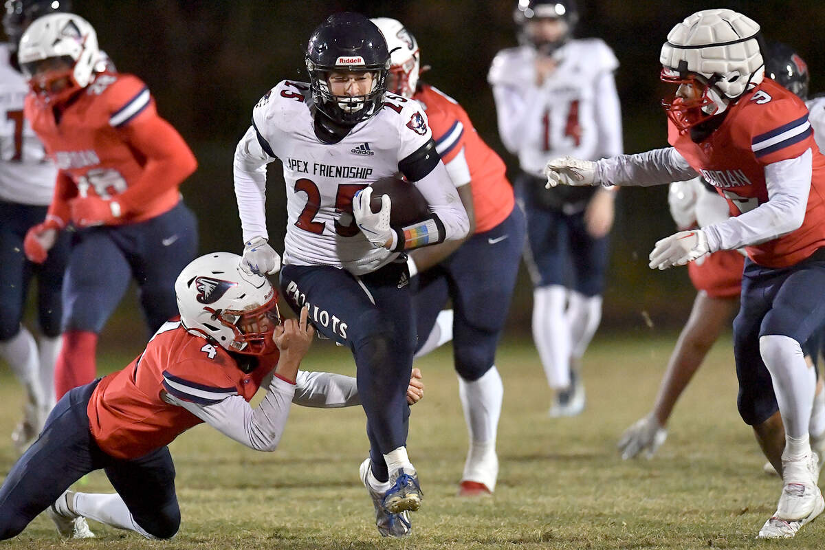 Apex Friendship’s Gavin Faulring (25)runs for yardage against Jordan’s Ezekiel Stokes (4) during the first half. The Apex Friendship Patriots and the Durham Jordan Falcons met in the second round of the NCHSAA 4A playoffs in Durham, N.C. on November 22, 2024.