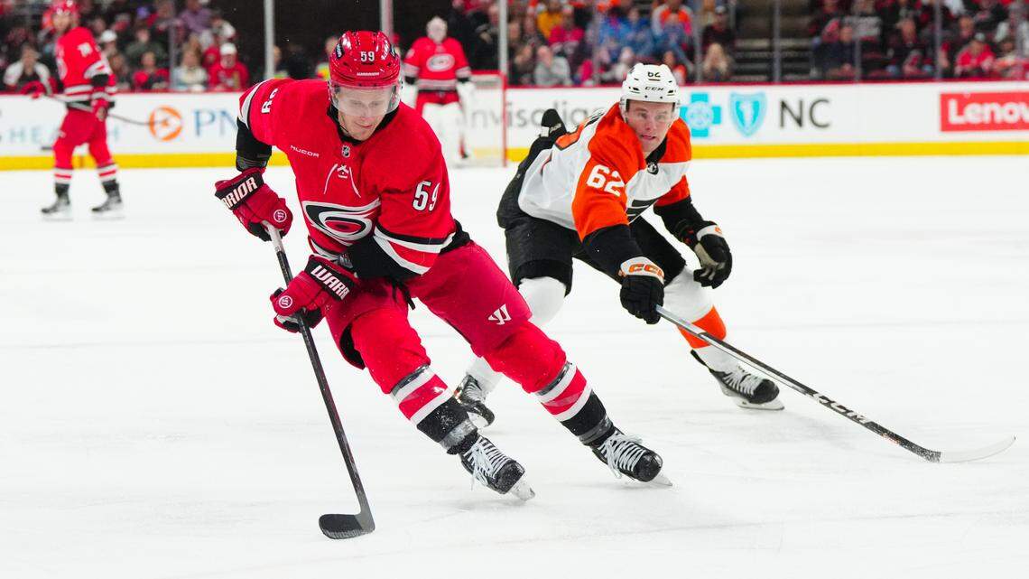 Mar 21, 2024; Raleigh, North Carolina, USA; Carolina Hurricanes left wing Jake Guentzel (59) skates with the puck past Philadelphia Flyers right wing Olle Lycksell (62) during the first period at PNC Arena. Mandatory Credit: James Guillory-USA TODAY Sports