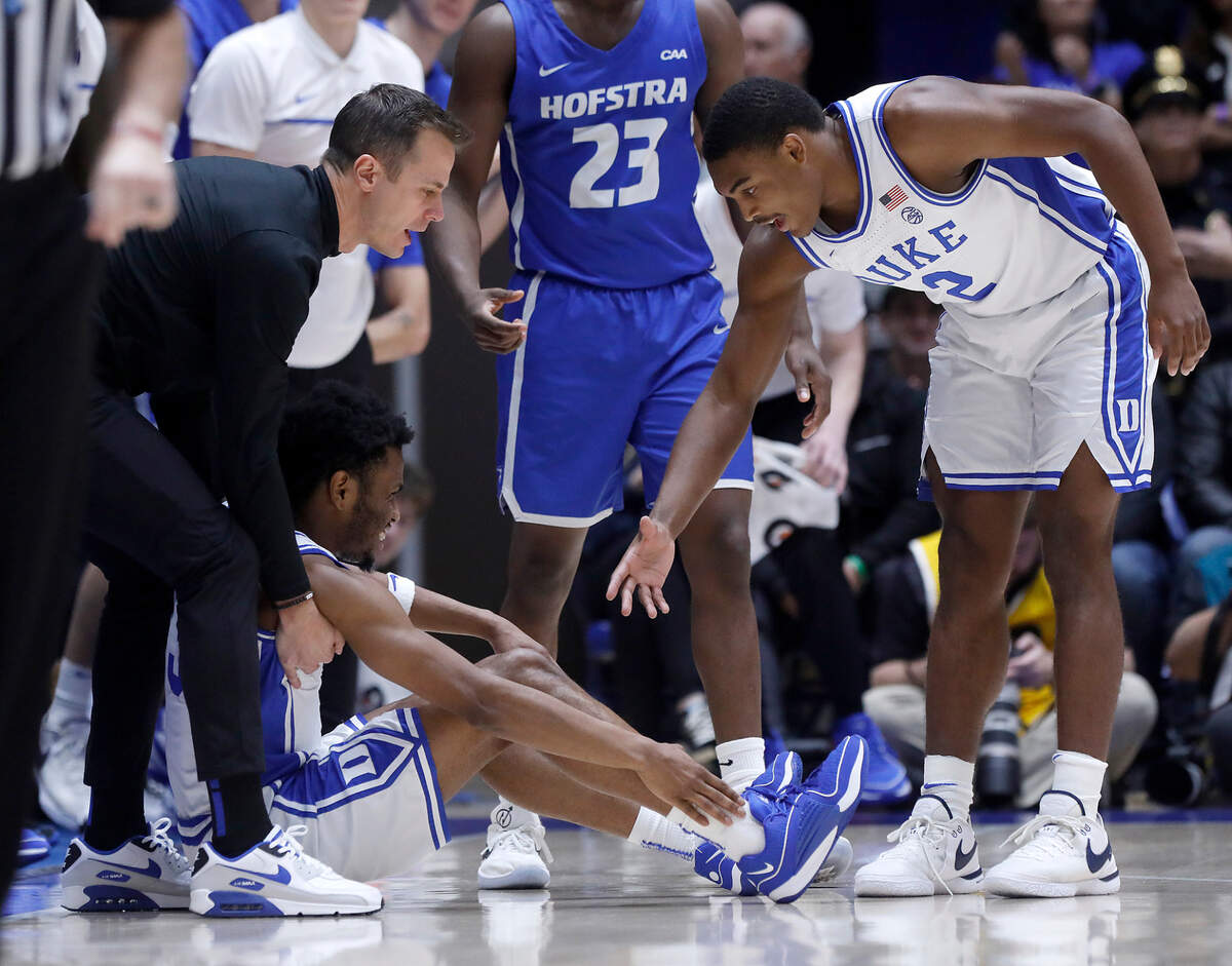 Duke head coach Jon Scheyer and Jaylen Blakes help up Jeremy Roach during the first half of the Blue Devils’ game against Hofstra on Tuesday, Dec. 12, 2023, at Cameron Indoor Stadium in Durham, N.C.
