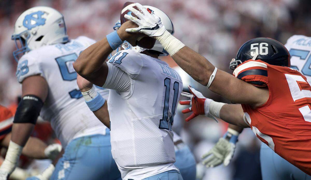Virginia’s Matt Gahm (56) gets a hand on the ball as North Carolina quarterback Nathan Elliott tries to pass in the third quarter on Saturday, October 27, 2018 at Scott Stadium in Charlottesville Va.