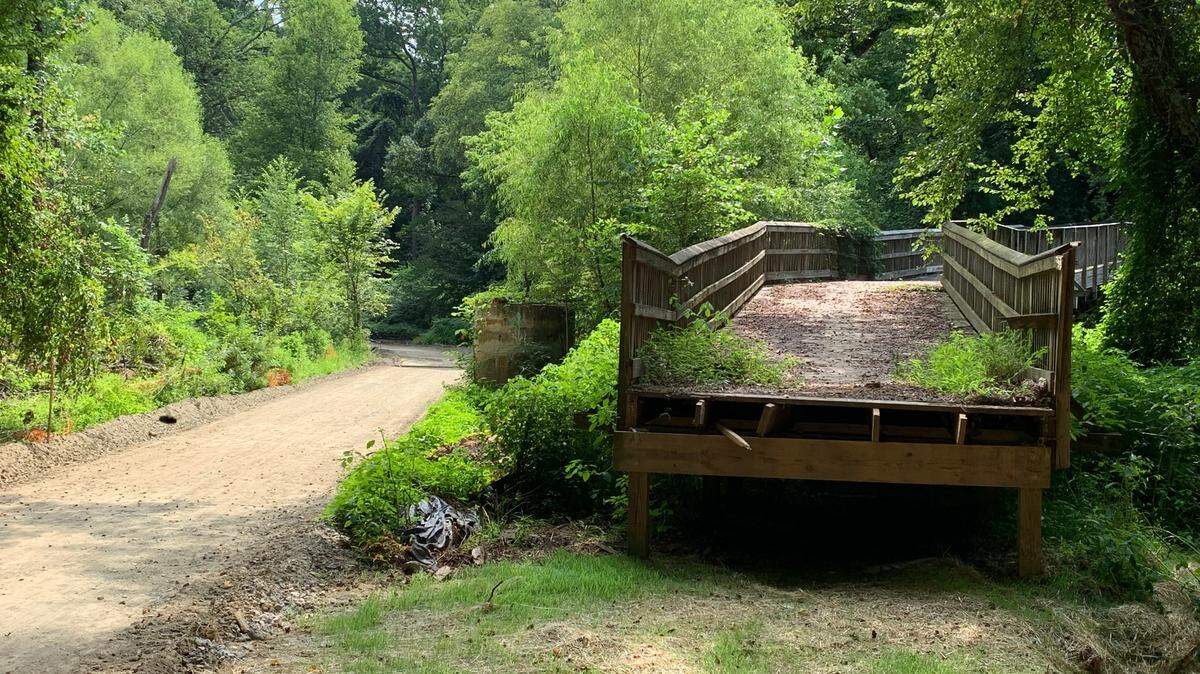 A new section of Crabtree Creek Trail, left, will remain at ground level, while the boardwalk along the creek, right, which failed in 2018, will be demolished.