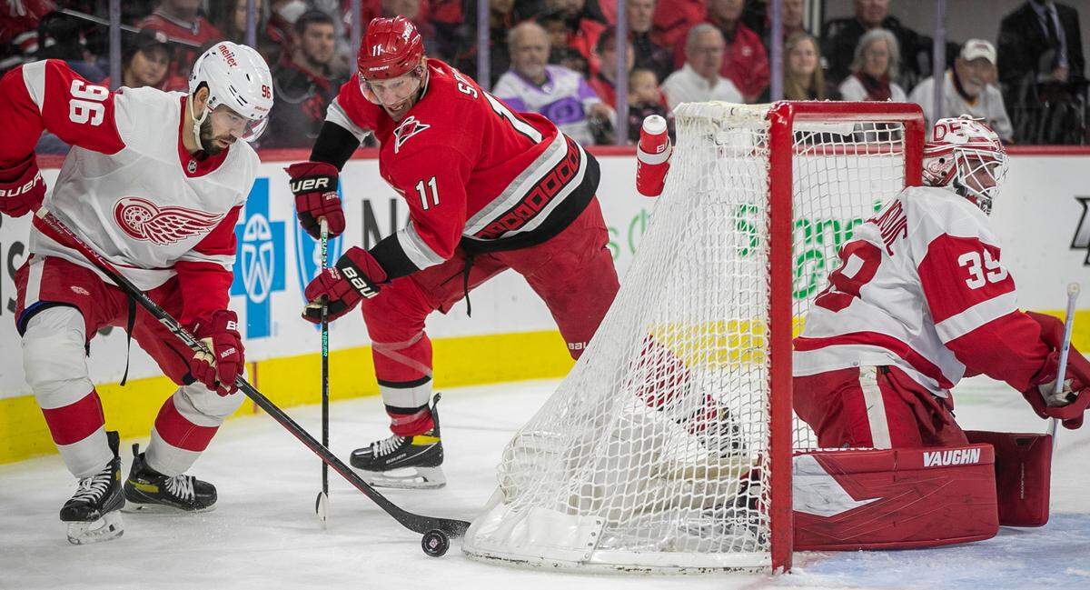 Carolina Hurricanes’ Jordan Staal (11) pressures Detroit’s Jake Walman (96) as he works to control the puck behind goalie Alex Nedeljkovic (39) in the first period on Tuesday, April 11, 2023 at PNC Arena in Raleigh, N.C.