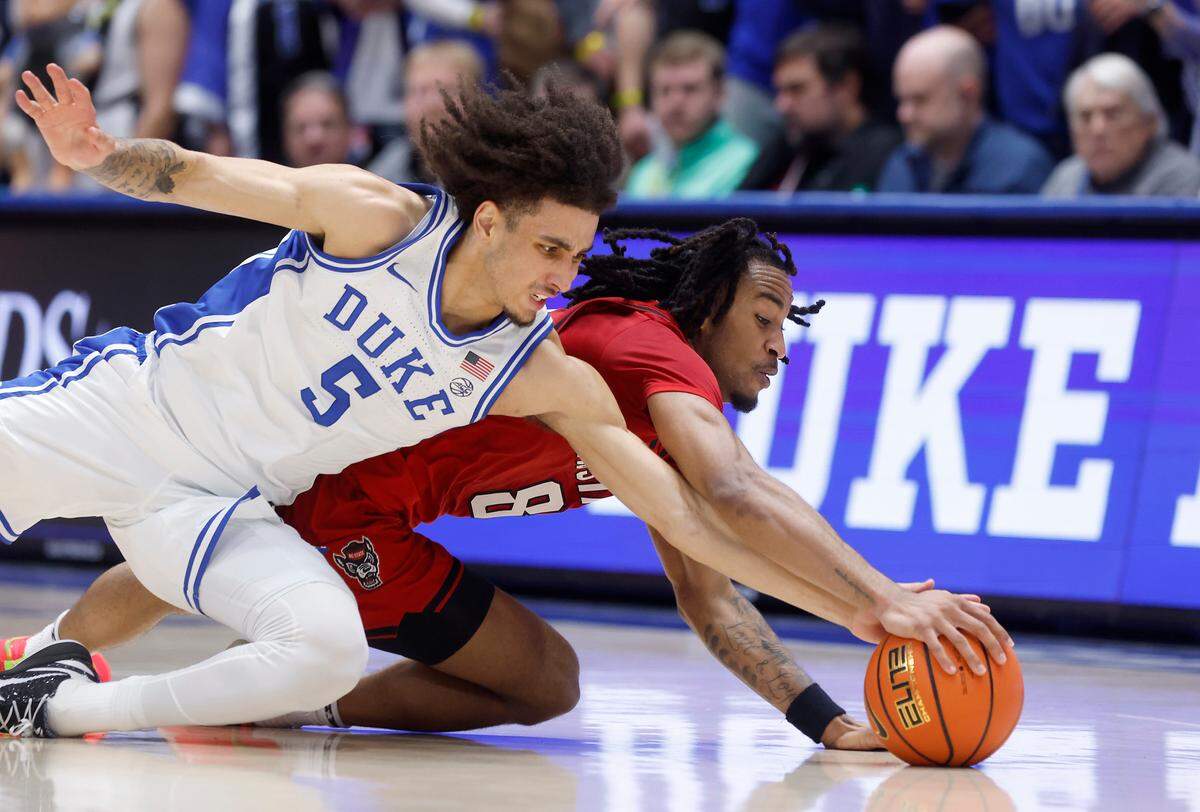Duke’s Tyrese Proctor and N.C. State’s Jayden Taylor dive after a loose ball during the first half of the Wolfpack’s game against Duke on Monday, Jan. 27, 2025, at Cameron Indoor Stadium in Durham, N.C.