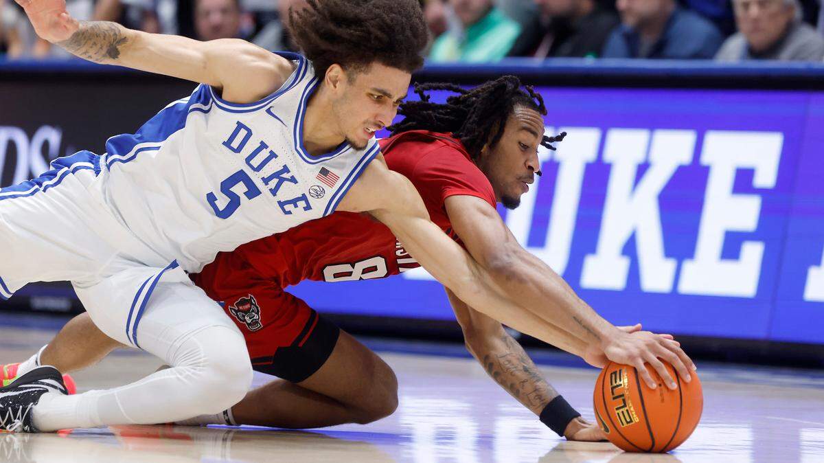 Duke’s Tyrese Proctor and N.C. State’s Jayden Taylor dive after a loose ball during the first half of the Wolfpack’s game on Monday, Jan. 27, 2025, at Cameron Indoor Stadium in Durham, N.C.
