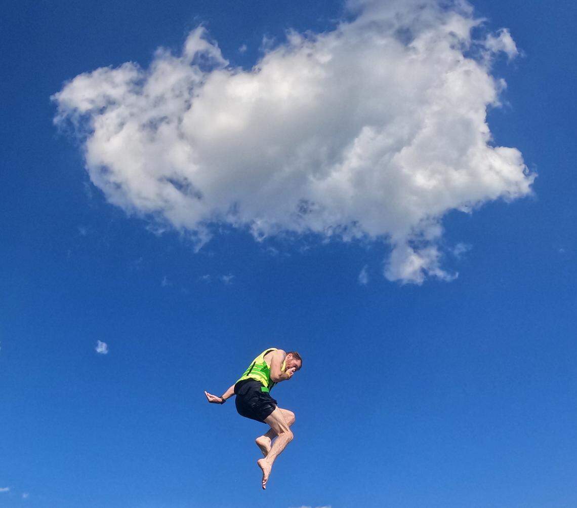A person jumps into the water at Fantasy Lake Adventure Park on Monday, July 31, 2023, in Wake Forest, N.C. The 65-acre lake offers an inflatable water park, kayaking, paddle boarding and scuba diving.