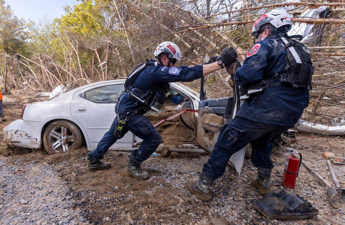 A FEMA search and rescue team from Maryland search for human remains in car in Swannanoa on Sunday, Oct. 6, 2024 after Tropical Storm Helene flooded the Swannanoa River. North Carolina officials have confirmed 76 deaths from Tropical Storm Helene.