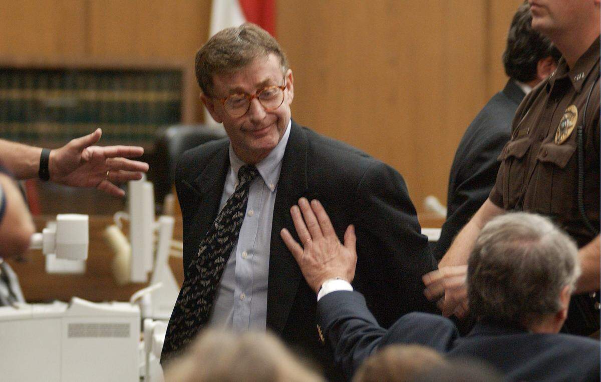 Michael Peterson looks to his family as Durham County Sherrif’s deputies lead him away on Oct. 10, 2003, after a jury found him guilty of first degree murder in the death of his wife Kathleen Peterson.