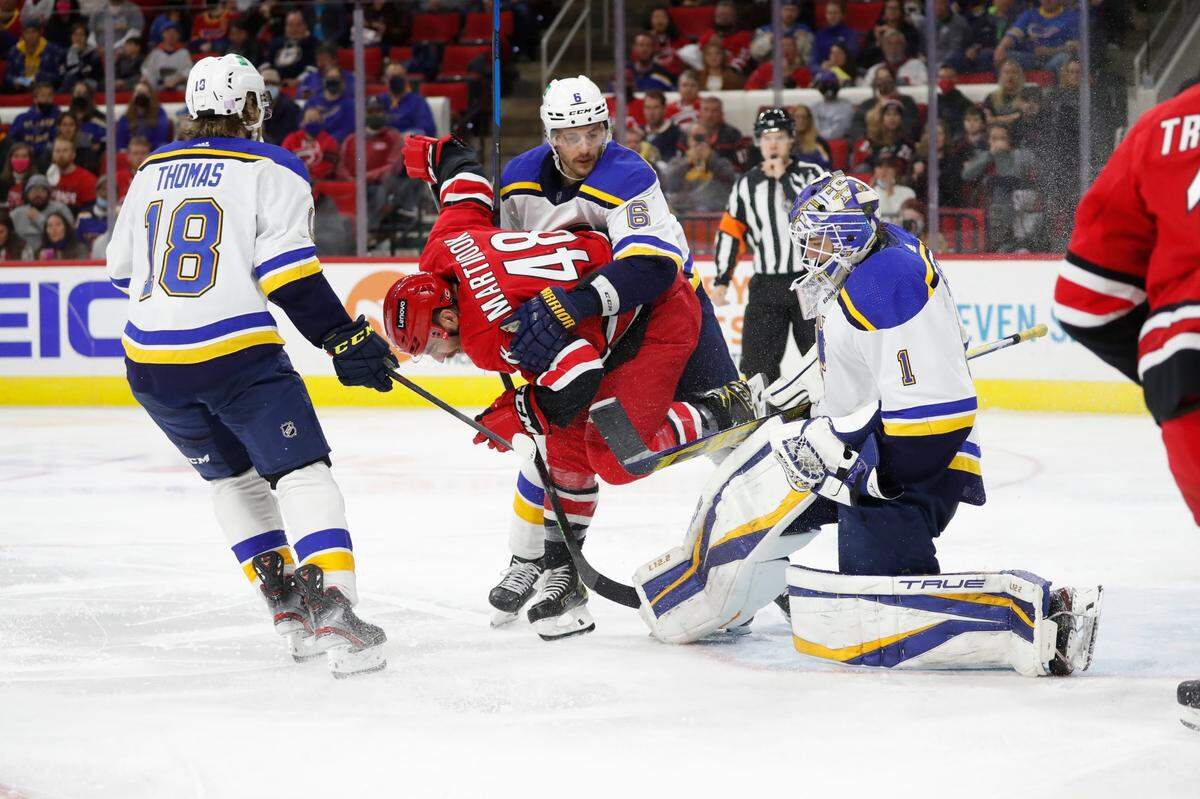 Carolina Hurricanes’ Jordan Martinook (48) gets tangled between St. Louis Blues’ Robert Thomas (18) and Marco Scandella (6) as goaltender Joel Hofer (1) makes a save during the second period of an NHL hockey game in Raleigh, N.C., Saturday, Nov. 13, 2021. (AP Photo/Karl B DeBlaker)
