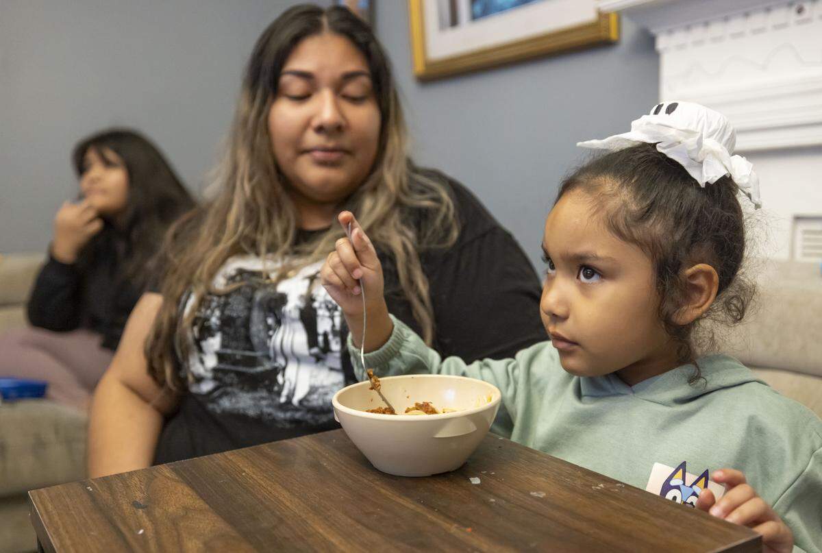 Beatriz Hernandez, who also goes by Betty, sits with her 5-year-old daughter Atzi Gonzalez as she dines on a bowl of spaghetti in her home on Wednesday, October 29, 2025 in Garner, N.C.