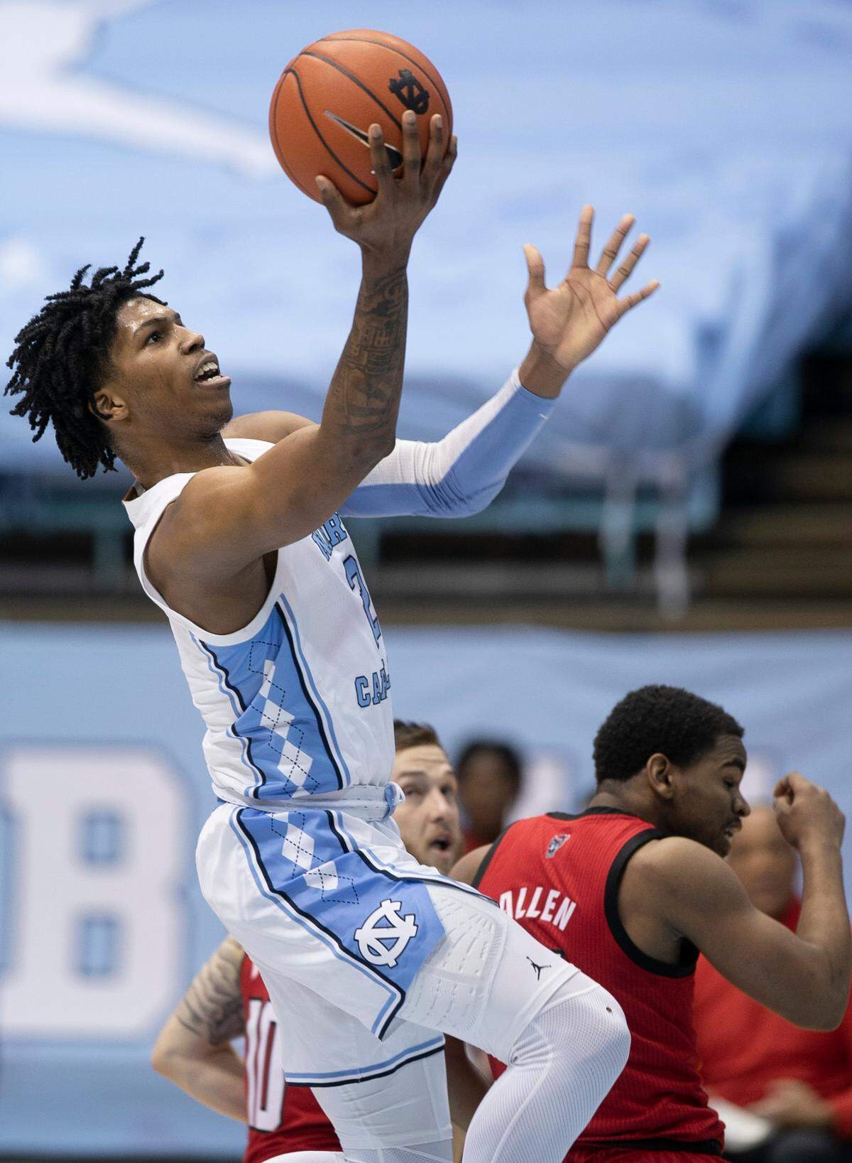 North Carolina’s Caleb Love (2) drives to the basket past NC State’s Braxton Beverly (10) and Thomas Allen (5) during the first half on Saturday, January 23, 2021 at the Smith Center in Chapel Hill, NC.