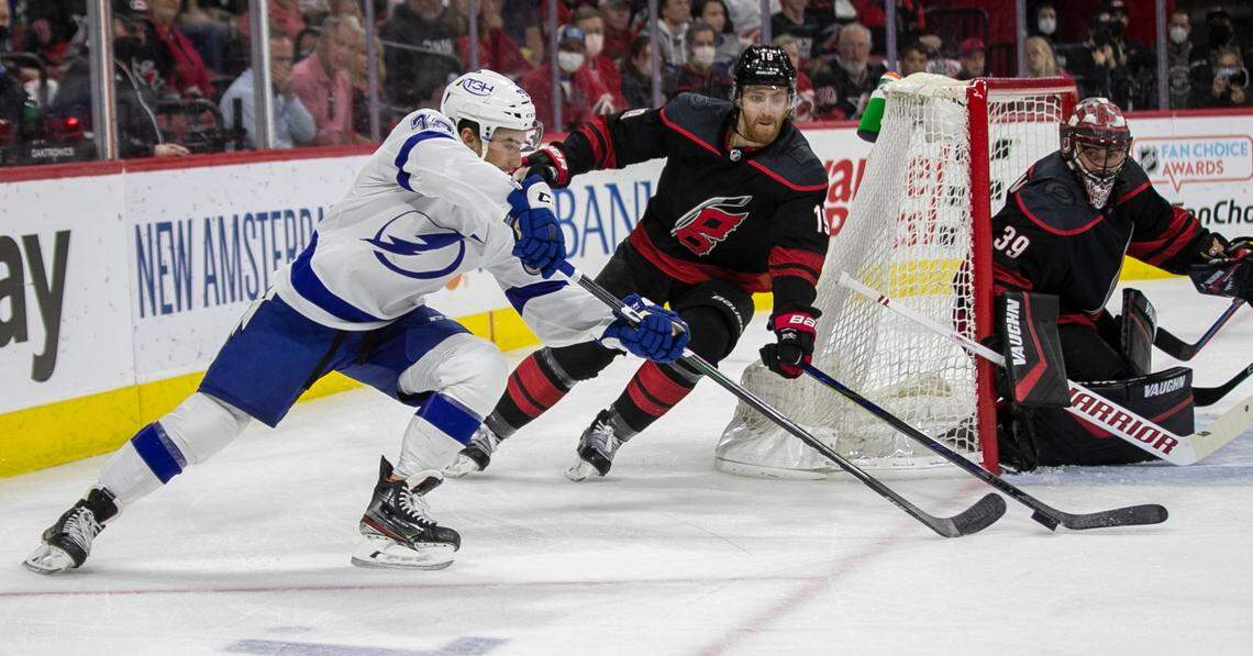 Tampa Bay’s Ross Colton (79) works the puck in close against Carolina Hurricanes’ Dougie Hamilton (19) and goalie Alex Nedeljkovic (39) during the first period in game five of their Stanley Cup series on Tuesday, June 8, 2021 at PNC Arena in Raleigh, N.C.