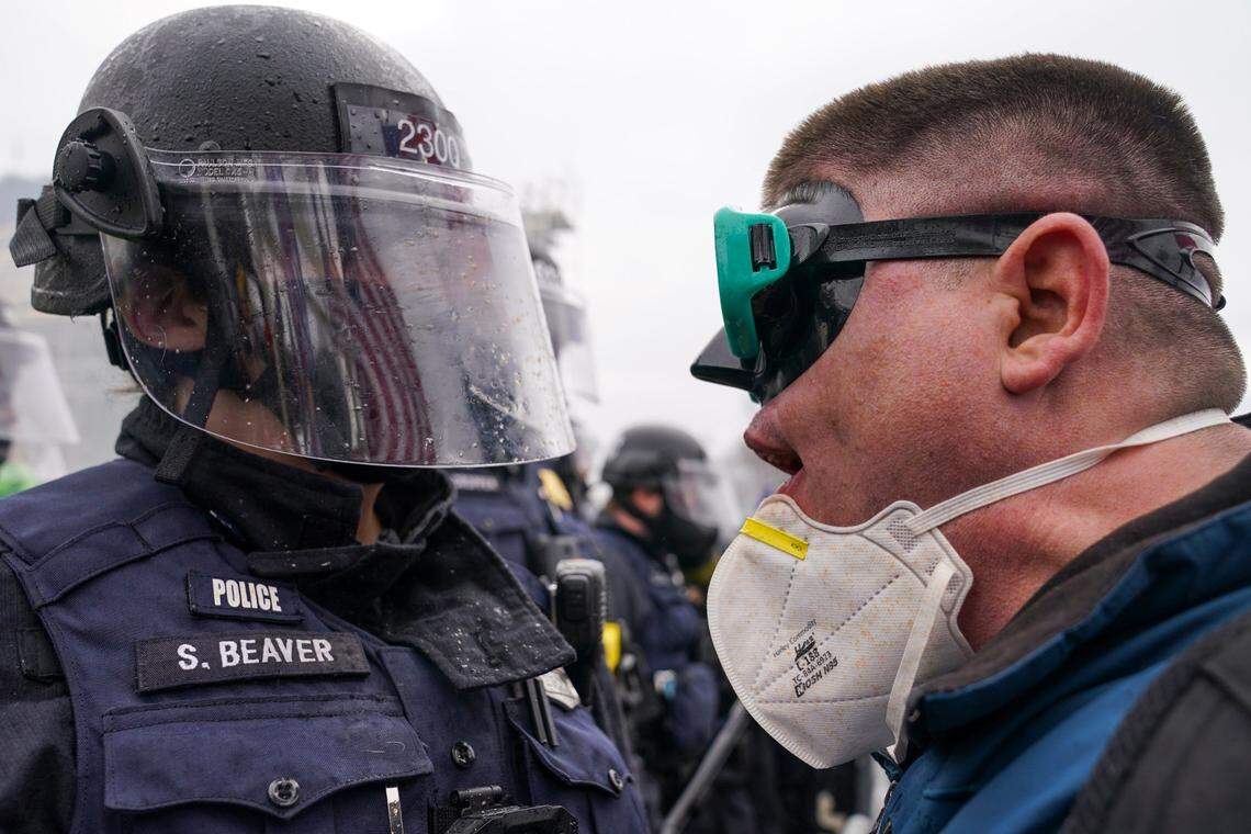 A demonstrator talks to police over a barrier, Wednesday, Jan. 6, 2021, at the Capitol in Washington. As Congress prepares to affirm President-elect Joe Biden’s victory, thousands of people have gathered to show their support for President Donald Trump and his claims of election fraud.