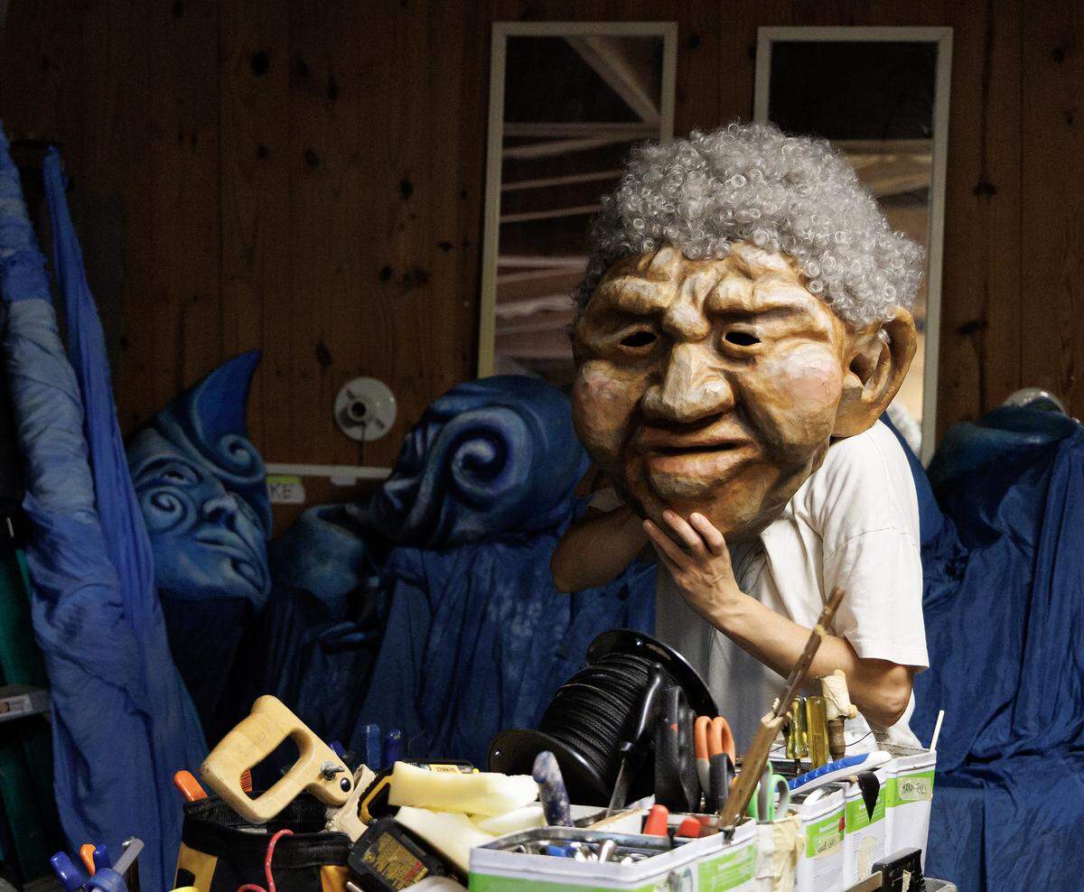 Amber Tarter, a puppeteer with Paperhand Puppet Intervention, tries on a puppet mask backstage prior to rehearsal for “The Gift” on Monday, Aug. 11, 2025, at the Forest Theatre in Chapel Hill, N.C.