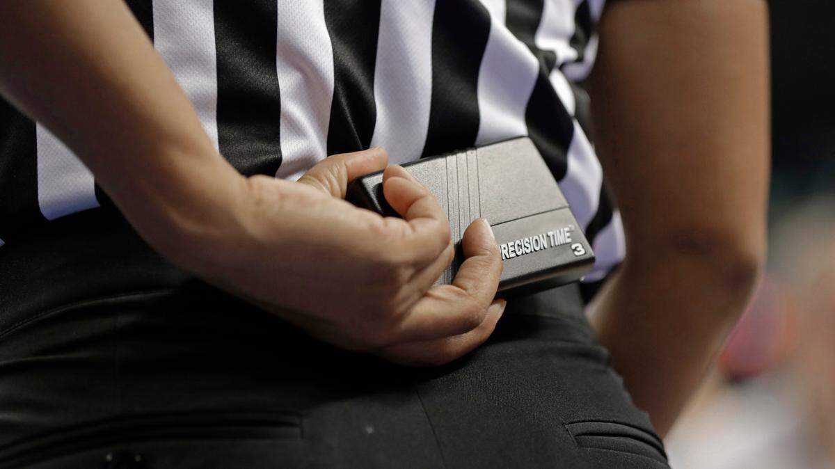 In this photo taken March 8, 2019, a referee prepares to start a play using a Precision Time device during the first half of an Atlantic Coast Conference women’s tournament basketball game in Greensboro, N.C. The Precision Time system created more than two decades ago by former referee Mike Costabile currently is used at nearly every level of the sport, including the NBA and college basketball’s NCAA Tournament. Costabile estimates the ability to stop the clock automatically on a referee’s whistle can save roughly 90 seconds formerly lost to reaction time when timekeepers manually stopped the clock. (AP Photo/Chuck Burton)