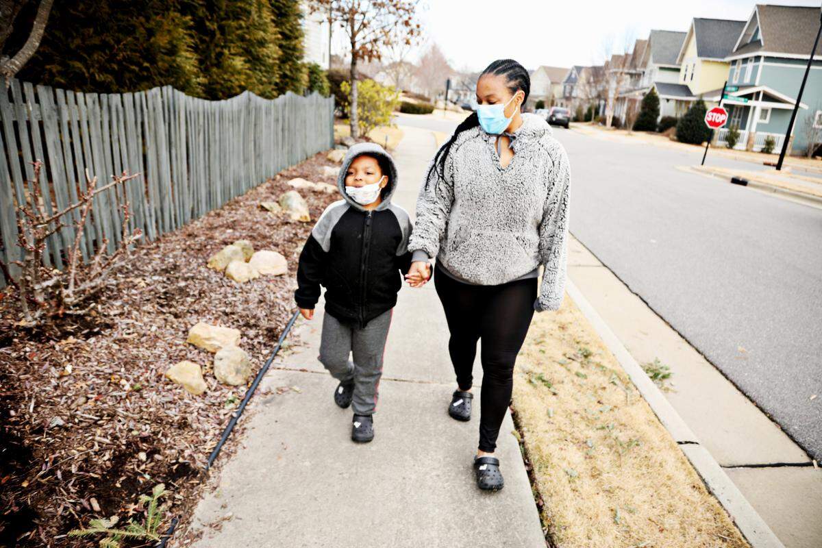 Laurel Farrar, right, with her six-year-old son, Jaiden Rodgers, in their Chapel Hill neighborhood on Tuesday, Jan 19, 2021. Rodgers, who is non-verbal, is struggling with online school so Farrar tries to fit in a lot of one-on-one time with her first grader while juggling a full-time job and her daughter.