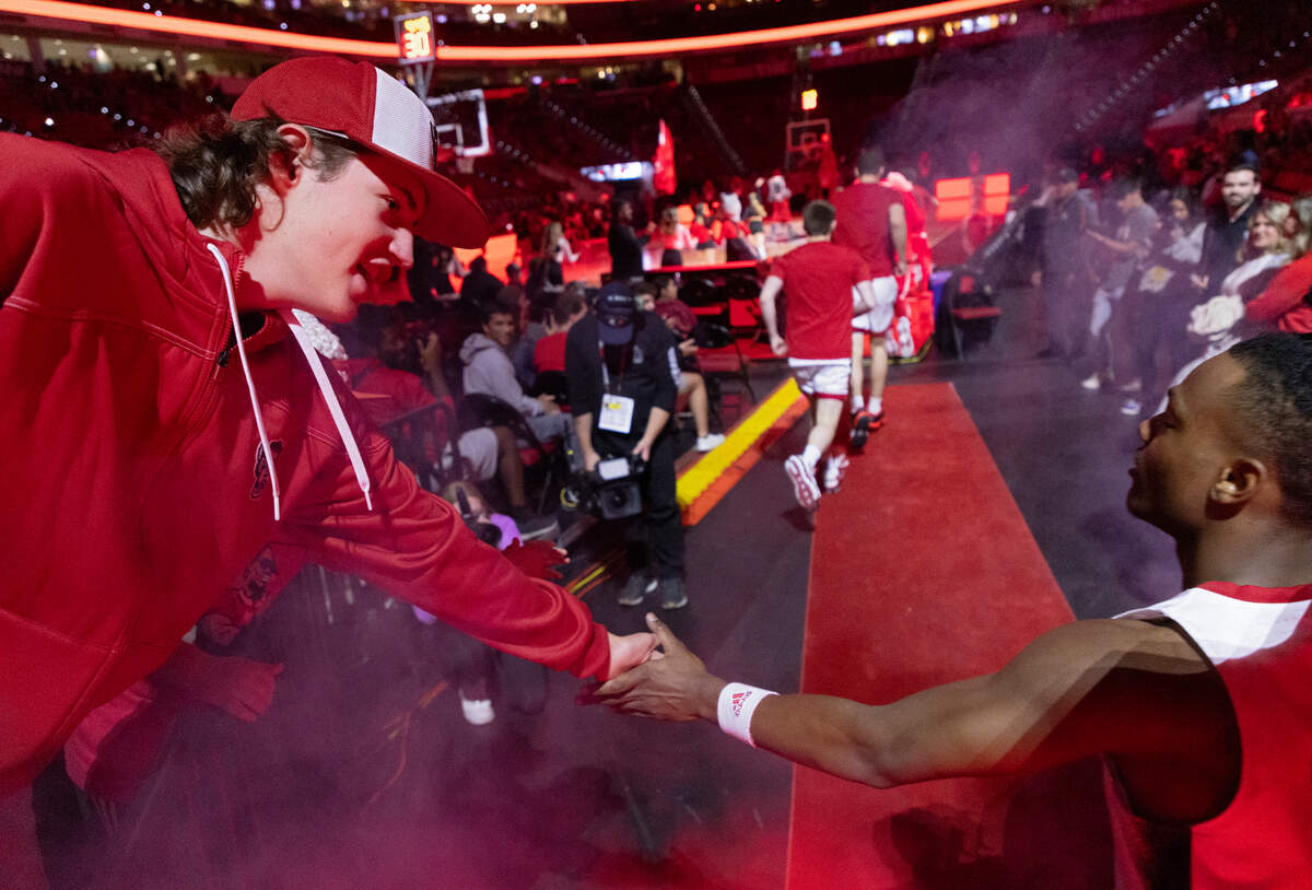 Carter Firebaugh high fives N.C. State’s DJ Horne as the Wolfpack take the court prior to their game against Abilene Christian on Friday, Nov. 10, 2023, at PNC Arena in Raleigh, N.C.