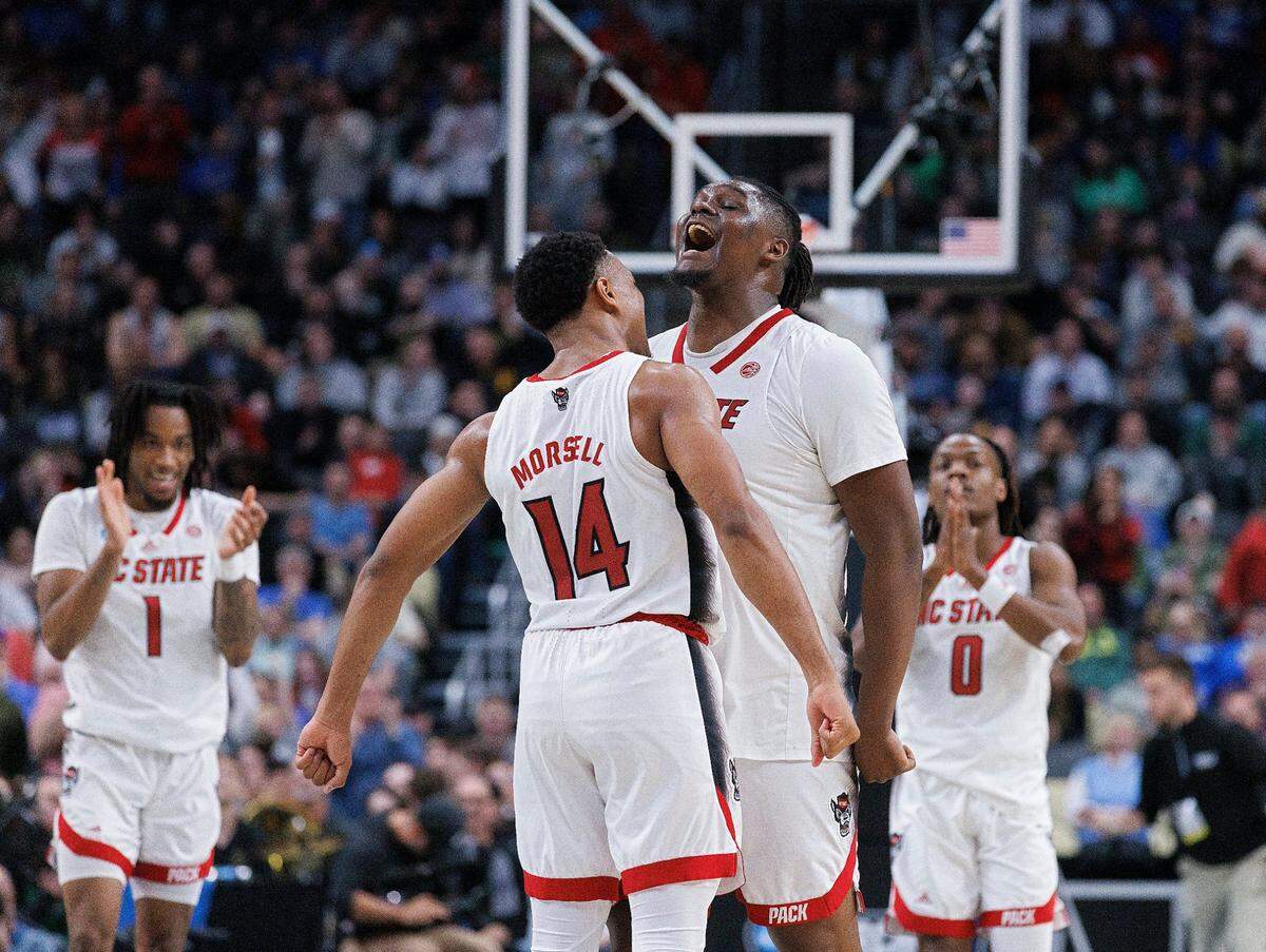 N.C. State’s Casey Morsell and DJ Burns Jr. celebrate in the closing seconds of the Wolfpack’s 79-73 overtime win over Oakland in the second round of the NCAA Tournament on Saturday, March 23, 2024, at PPG Paints Arena in Pittsburgh, Pa.