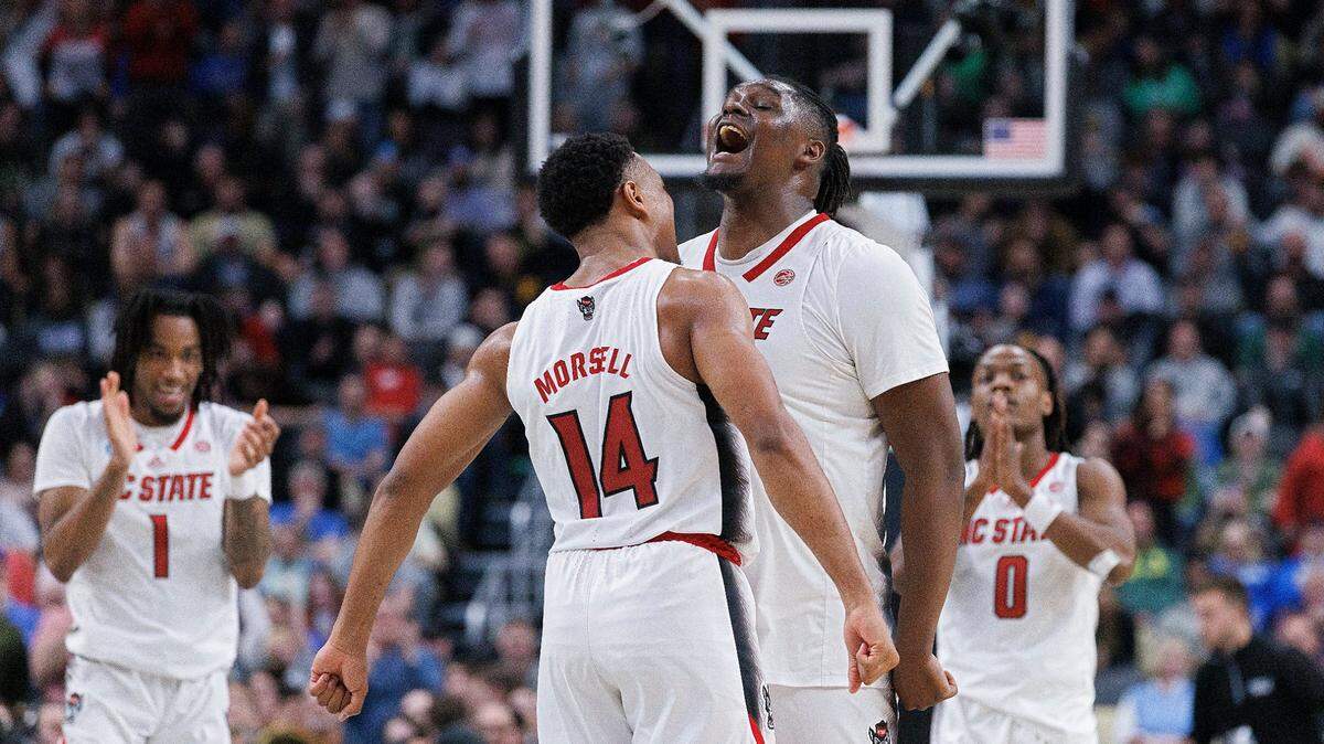 N.C. State’s Casey Morsell and DJ Burns Jr. celebrate in the closing seconds of the Wolfpack’s 79-73 overtime win over Oakland in the second round of the NCAA Tournament on Saturday, March 23, 2024, at PPG Paints Arena in Pittsburgh, Pa.