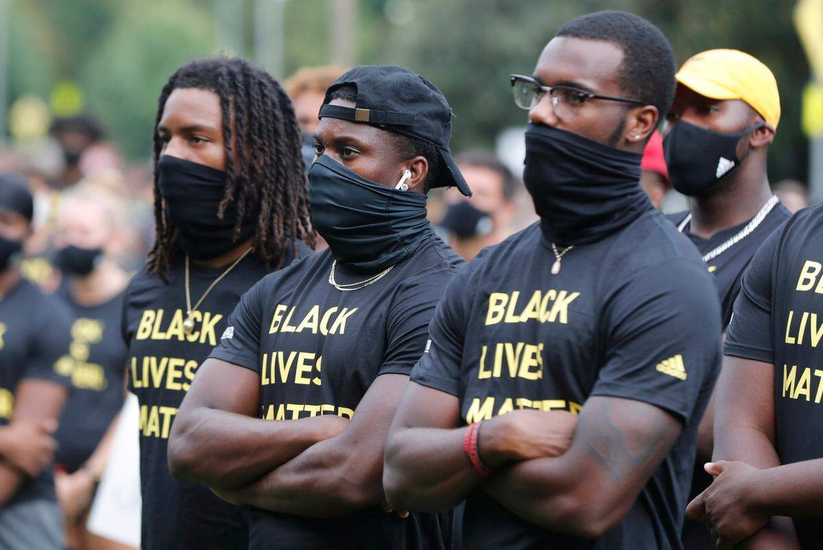 N.C. State athletes, coaches and staff listen to the speakers during a #PackUnited peaceful protest against racial and social injustice outside Holladay Hall on the campus of N.C. State Saturday, Sept. 12, 2020.