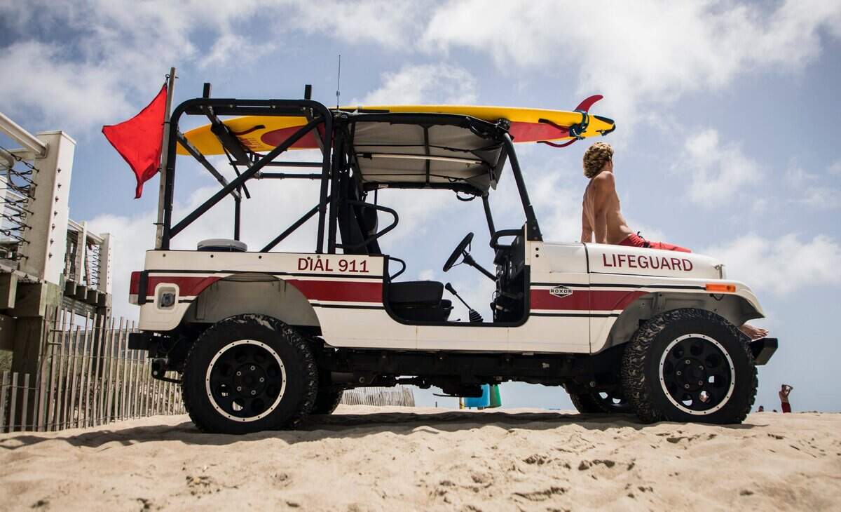 Emerald Isle lifeguard Jacob Price watches swimmers in the waters near Bogue Inlet Pier in Emerald Isle, N.C. on Sunday, August 2, 2020. A red flag flies to signify hazardous swimming conditions as Tropical Storm Isaias approaches the southeast.