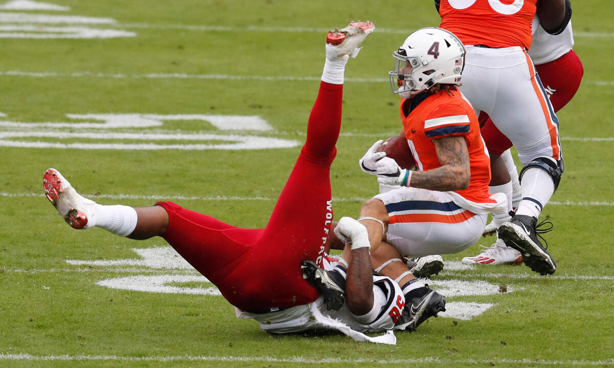 N.C. State defensive lineman Nick Booker-Brown (58) tackles Virginia running back Billy Kemp IV (4) during the first half of N.C. State’s game against Virginia at Scott Stadium in Charlottesville, Va., Saturday, Oct. 10, 2020.