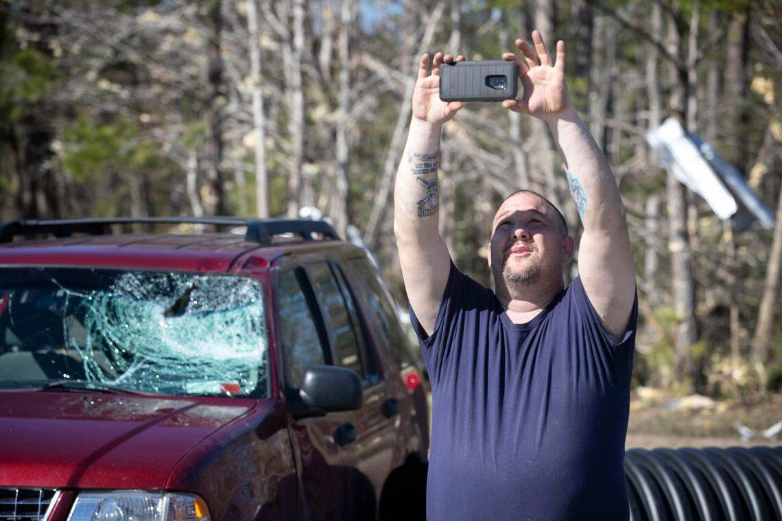 Dell Olley shows his insurance agent, via live video, the damage to his father’s truck at Total Lane Care on Seaside Road near Sunset Beach, N.C. on Tuesday, February 16, 2021 after a tornado ripped through the Brunswick County community late Monday night.