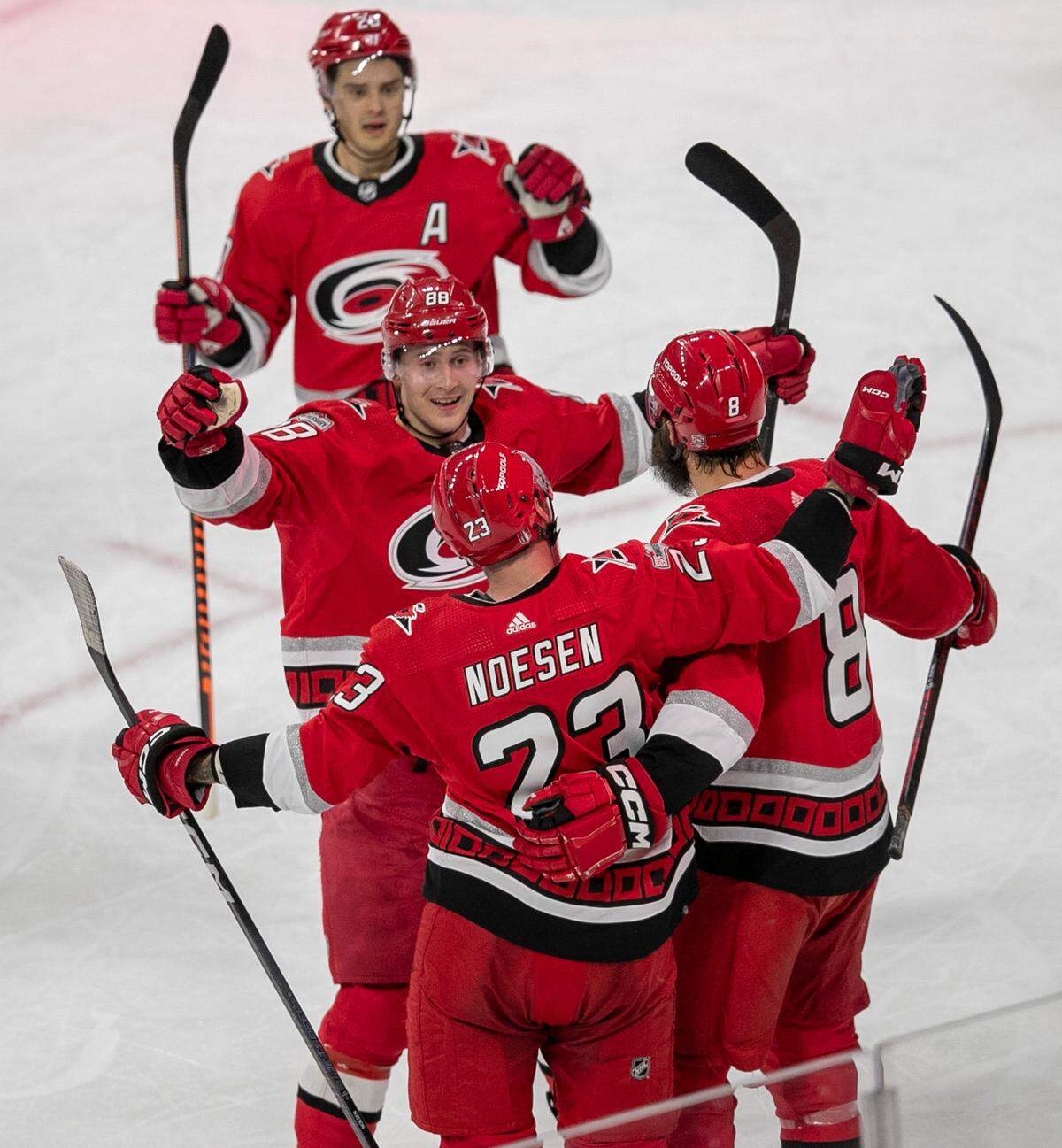 Carolina Hurricanes’ Stefan Noesen (23) celebrates with Brent Burns (8), Martin Necas (88) and Sebastian Aho (20) after scoring in the second period to take a 2-0 lead during game two of their Stanley Cup series on Wednesday, April 19, 2023 at PNC Arena in Raleigh, N.C.