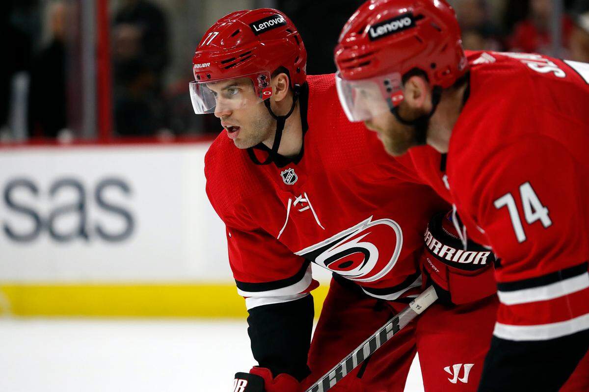 Carolina Hurricanes’ Tony DeAngelo (77) waits for a face-off near teammate Jaccob Slavin (74) during the third period of an NHL hockey game against the Montreal Canadiens in Raleigh, N.C., Thursday, March 31, 2022. (AP Photo/Karl B DeBlaker)