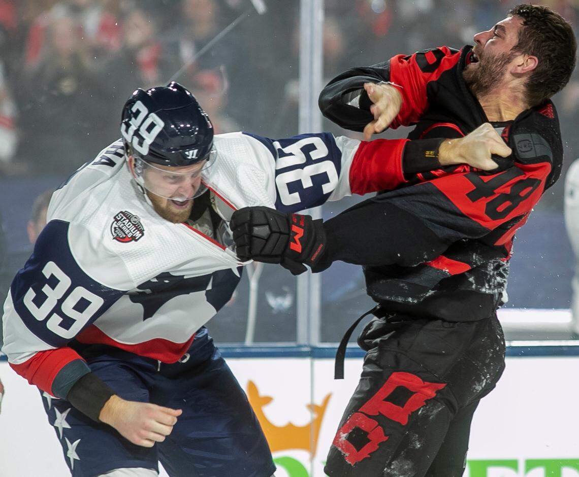 Washington Capitals’ Anthony Mantha (39) fights with Carolina Hurricanes’ Jordan Martinook (48) during the second period in the Stadium Series game on Saturday, February 18, 2022 at Carter-Finley Stadium in Raleigh, N.C