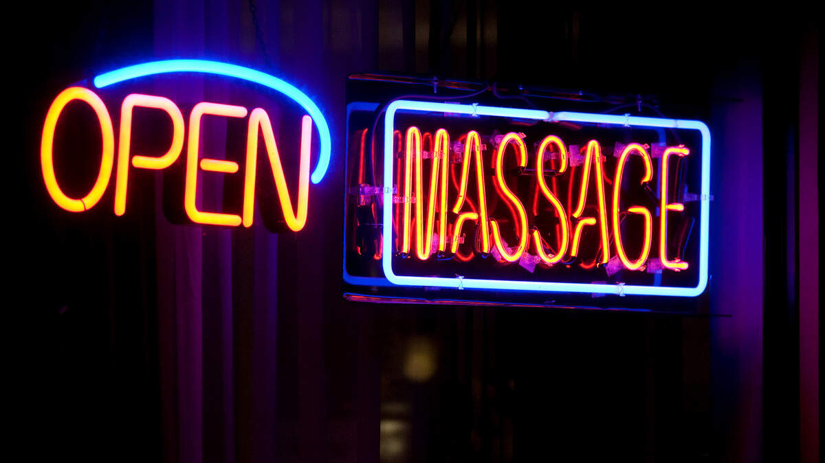 (DARRYL BUSH/dbush@modbee.com) - Neon signs in a window advertise as police investigate after an assault in a massage parlor on McHenry Ave. near Woodrow Ave., in Modesto, Calif., on Monday, February 28, 2011.