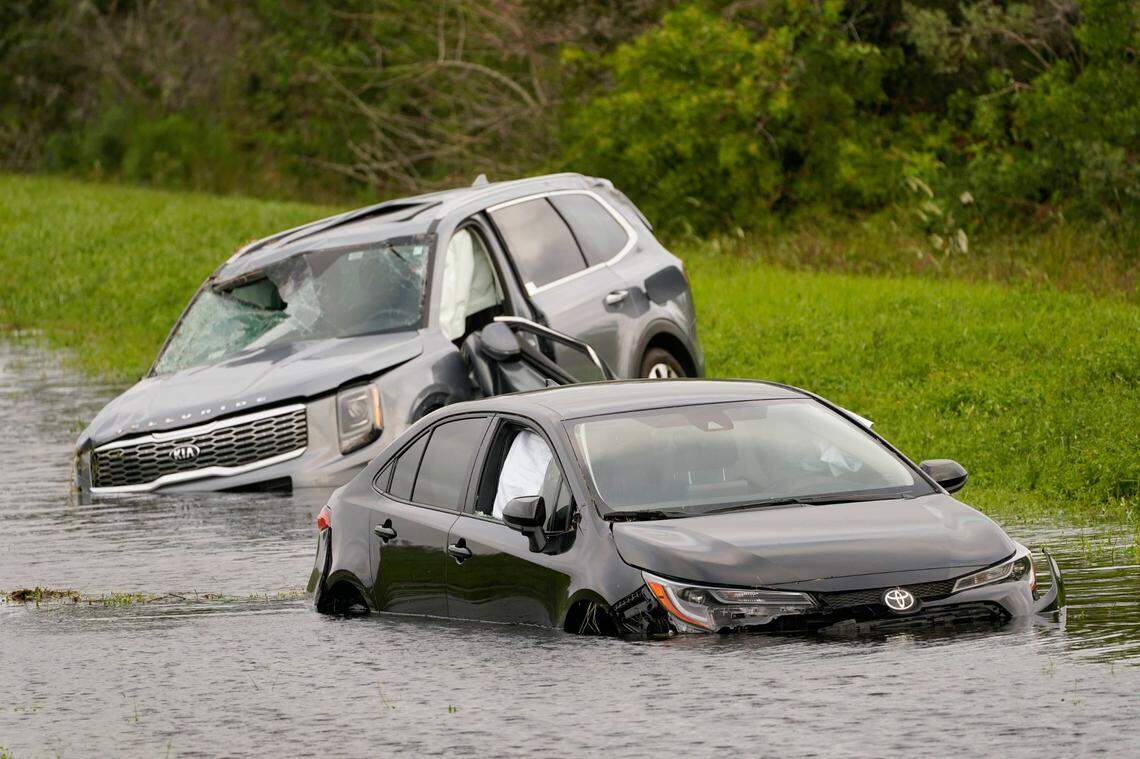 Vehicles sit in floodwaters on the side of Interstate 75 in North Port, Fla., following Hurricane Ian, Thursday, Sept. 29, 2022.