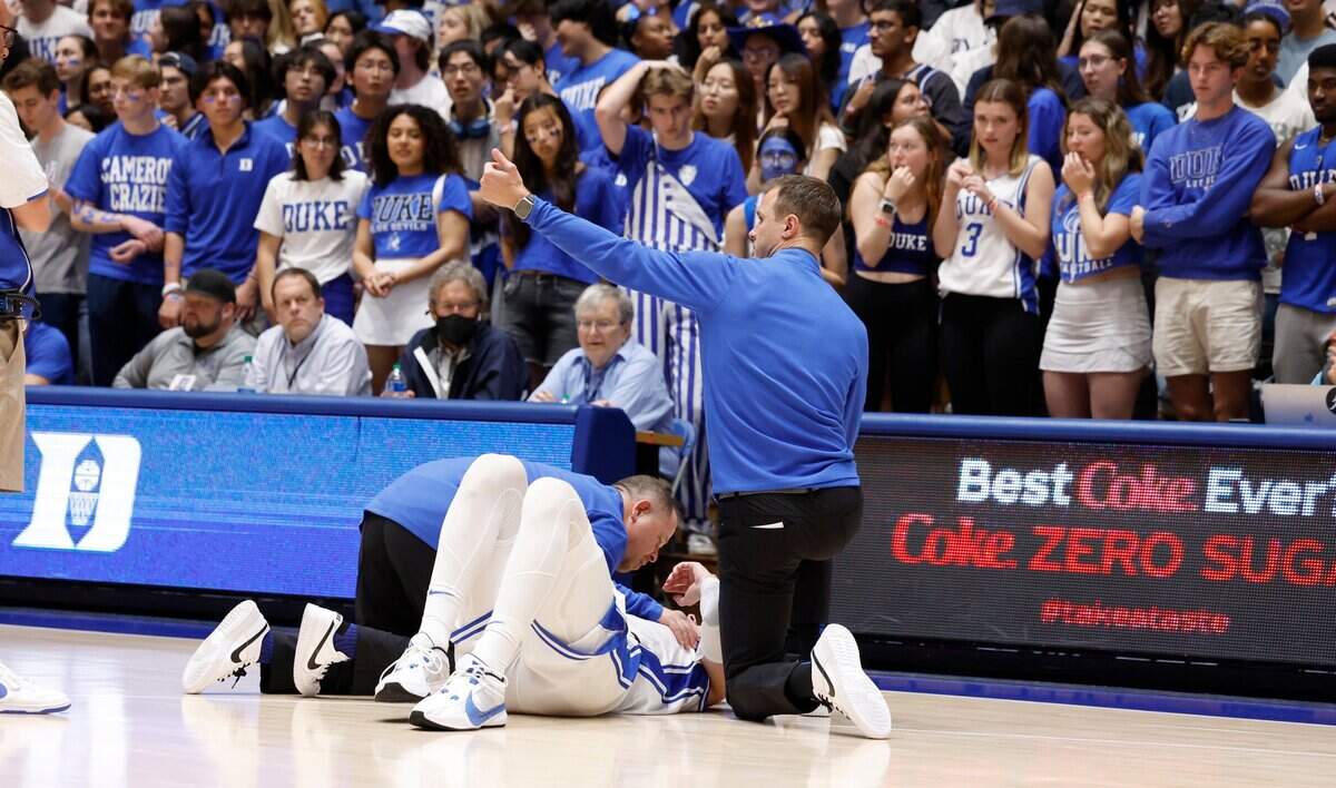 Duke trainer Jose Fonseca and head coach Jon Scheyer look at Kyle Filipowski after he was injured during the first half of Duke’s game against Bucknell at Cameron Indoor Stadium in Durham, N.C., Friday, Nov. 17, 2023.