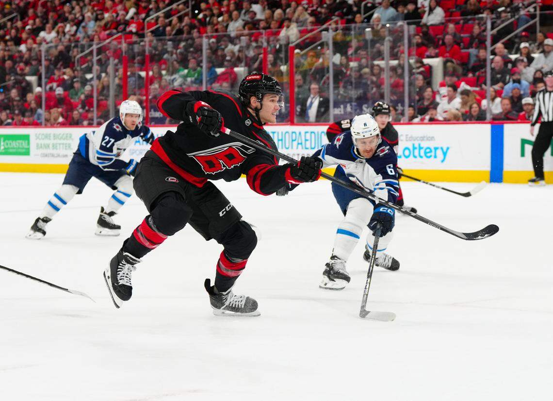Mar 9, 2025; Raleigh, North Carolina, USA; Carolina Hurricanes center Mark Jankowski (77) scores a goal on his shot past Winnipeg Jets defenseman Colin Miller (6) during the first period at Lenovo Center. Mandatory Credit: James Guillory-Imagn Images