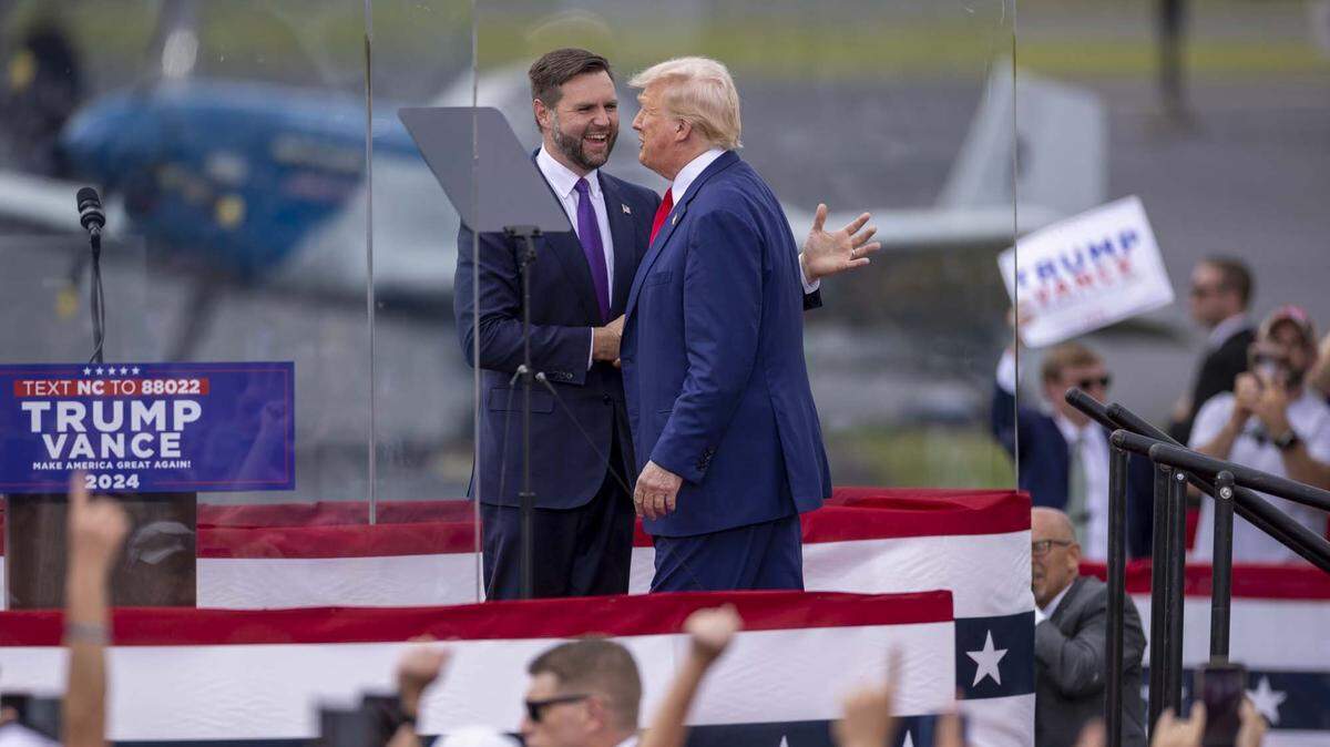 Sen. JD Vance greets former President Donald Trump on stage during a rally at the North Carolina Aviation Museum & Hall of Fame in Asheboro, NC on Wednesday, Aug. 21, 2024.