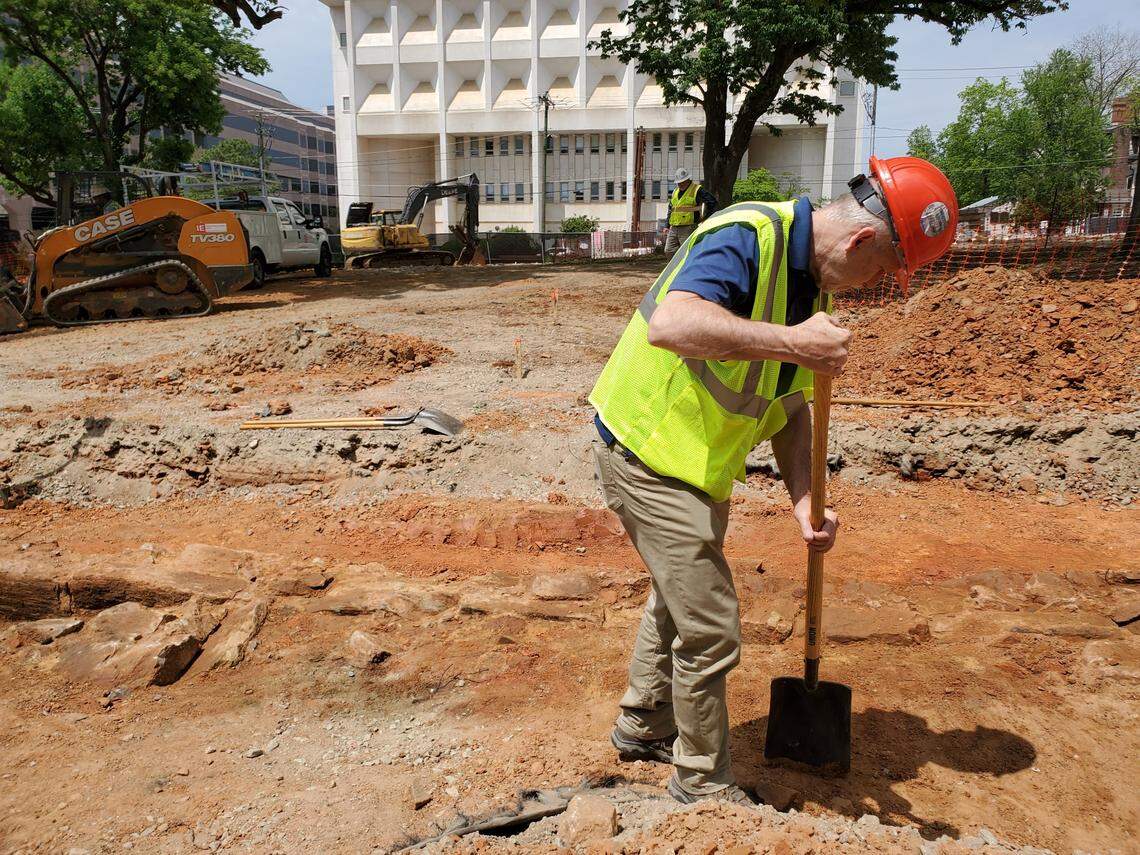 North Carolina state archaeologist John Mintz works on Friday, April 29, 2022, to reveal the stone foundation wall of an 1850 house that was left underground when the state bought the property in the 1960s. The foundation wall will be removed and could be incorporated into the final NC Freedom Park, which is being built in downtown Raleigh. In the distance behind him in is the Bath Building.