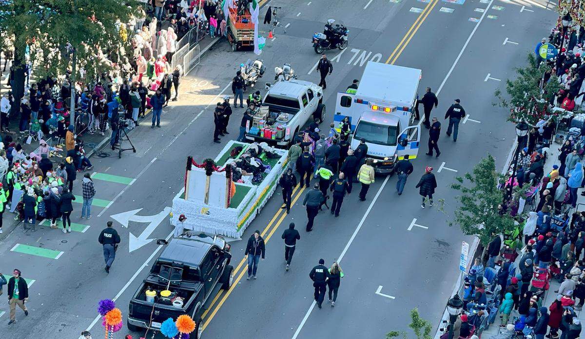 Rescuers take a young girl to the ambulance after she was struck by an out of control truck, left, at the Raleigh Christmas Parade Saturday, Nov. 19, 2022. The girl, 11-year-old Hailey Brooks, was killed.