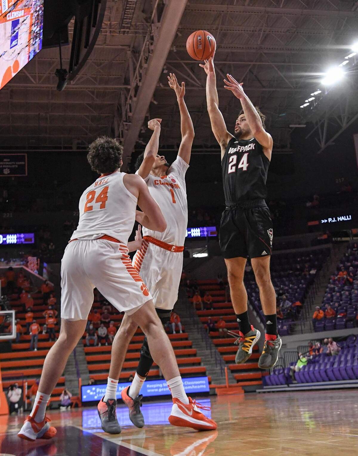 NC State guard Devon Daniels(24) shoots as Clemson senior forward Jonathan Baehre(1) defends during the first half of their game on January 5, 2021.
