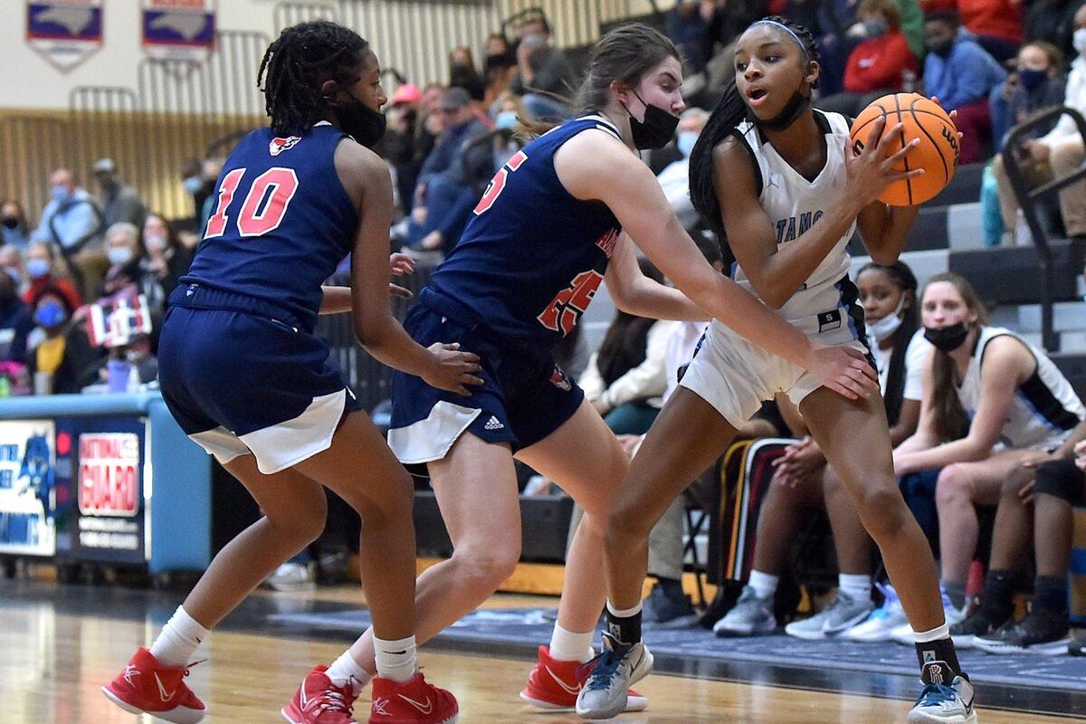 Apex Friendship’s Victoris Sagne (10) and Marlee Beam (24) defend Panther Creek’s Taylor Barner (2) The Panther Creek Catamounts and the Apex Friendship Patriots met in a conference basketball game in Cary, NC on January 28, 2022.