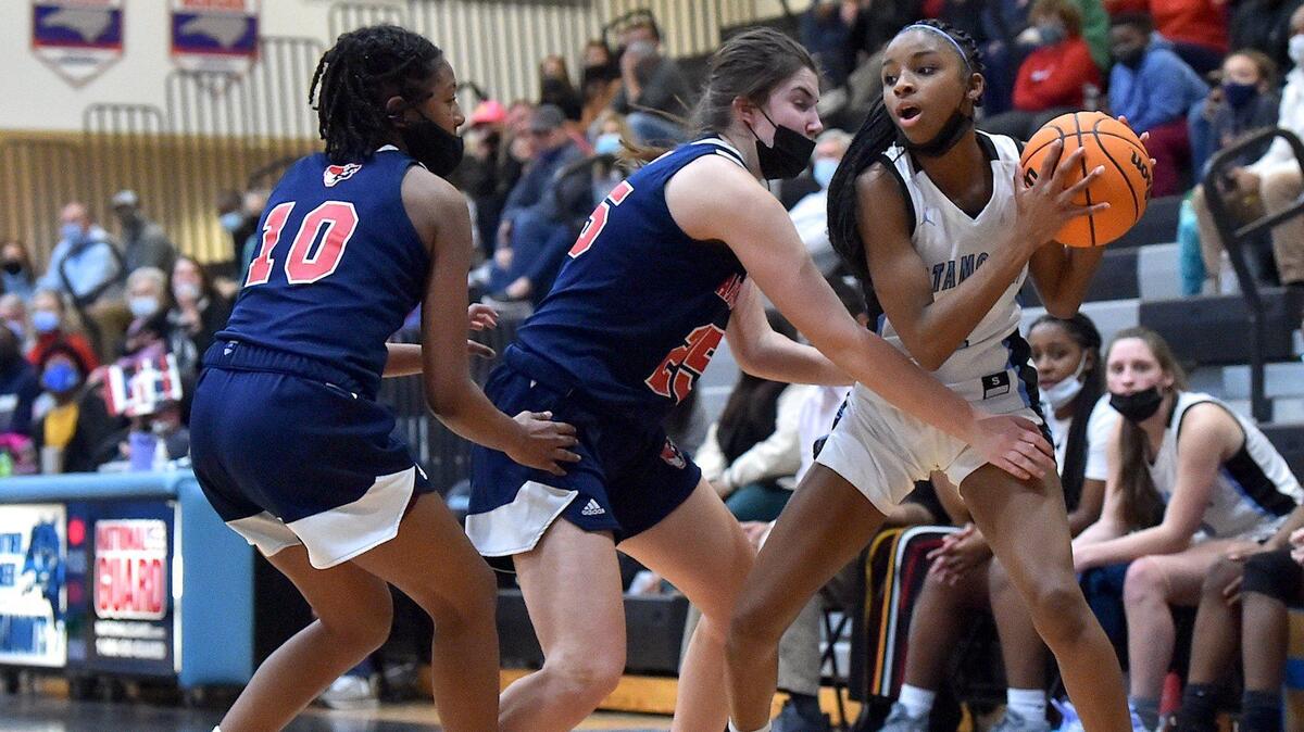 Apex Friendship’s Victoris Sagne (10) and Marlee Beam (24) defend Panther Creek’s Taylor Barner (2) The Panther Creek Catamounts and the Apex Friendship Patriots met in a conference basketball game in Cary, NC on January 28, 2022.