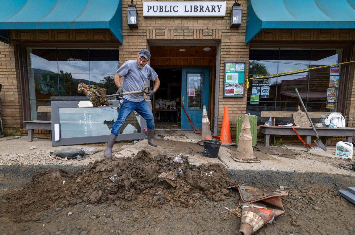 Volunteer Justin Moon shovels mud from the public library on Friday, October 4, 2024 in Hot Springs, N.C after flood waters from Hurricane Helen filled the building one week ago.