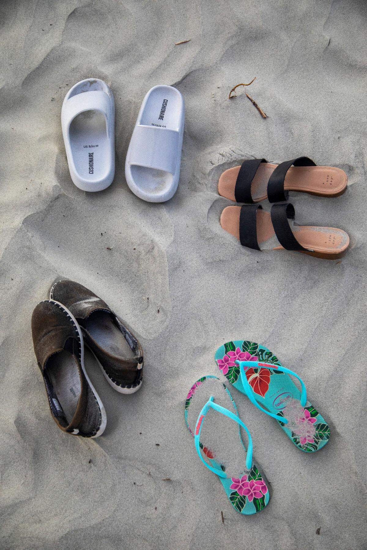 Shoes and sandals lay in the sand on Sunset Beach.