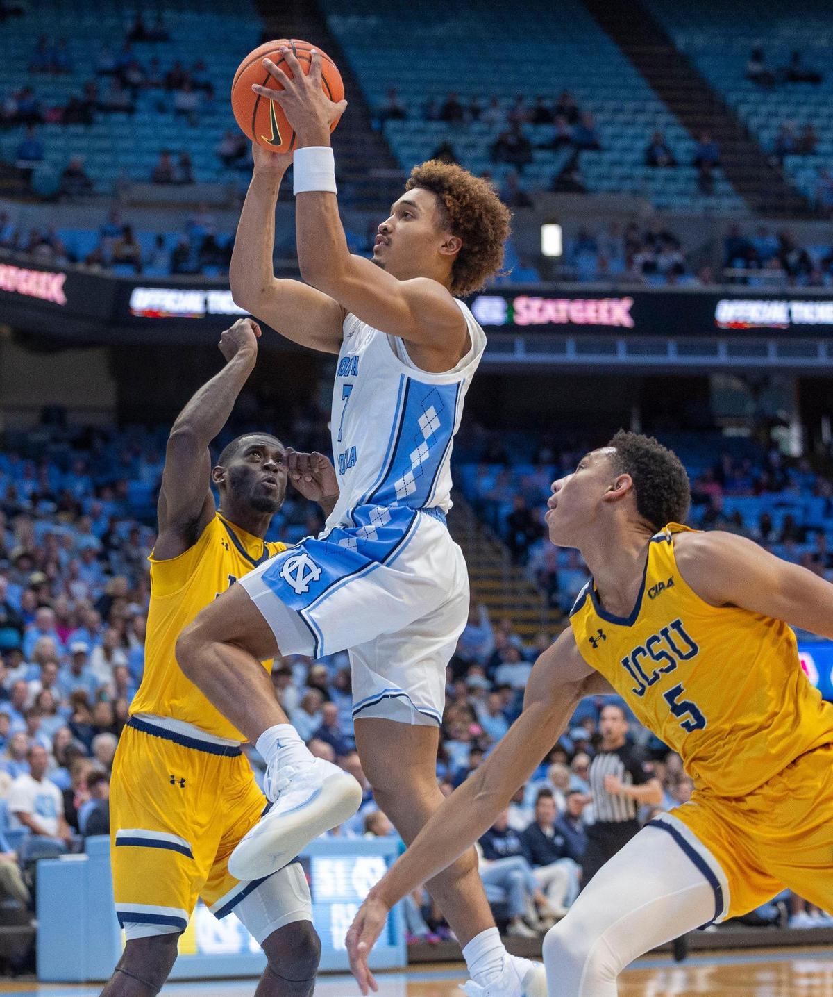 North Carolina guard Seth Trimble (7) drives to the basket against Johnson C. Smith’s Gavin Cannady (2) and Justin Bumbray (5) during the first half on Sunday, October 27, 2024 at the Smith Center in Chapel Hill, N.C.