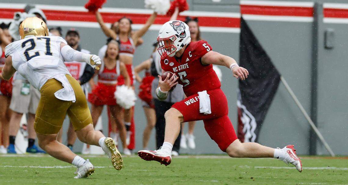 N.C. State quarterback Brennan Armstrong (5) scrambles for yards during the first half of N.C. State’s game against Notre Dame at Carter-Finley Stadium in Raleigh, N.C., Saturday, Sept. 9, 2023. Notre Dame linebacker JD Bertrand (27) closes in.