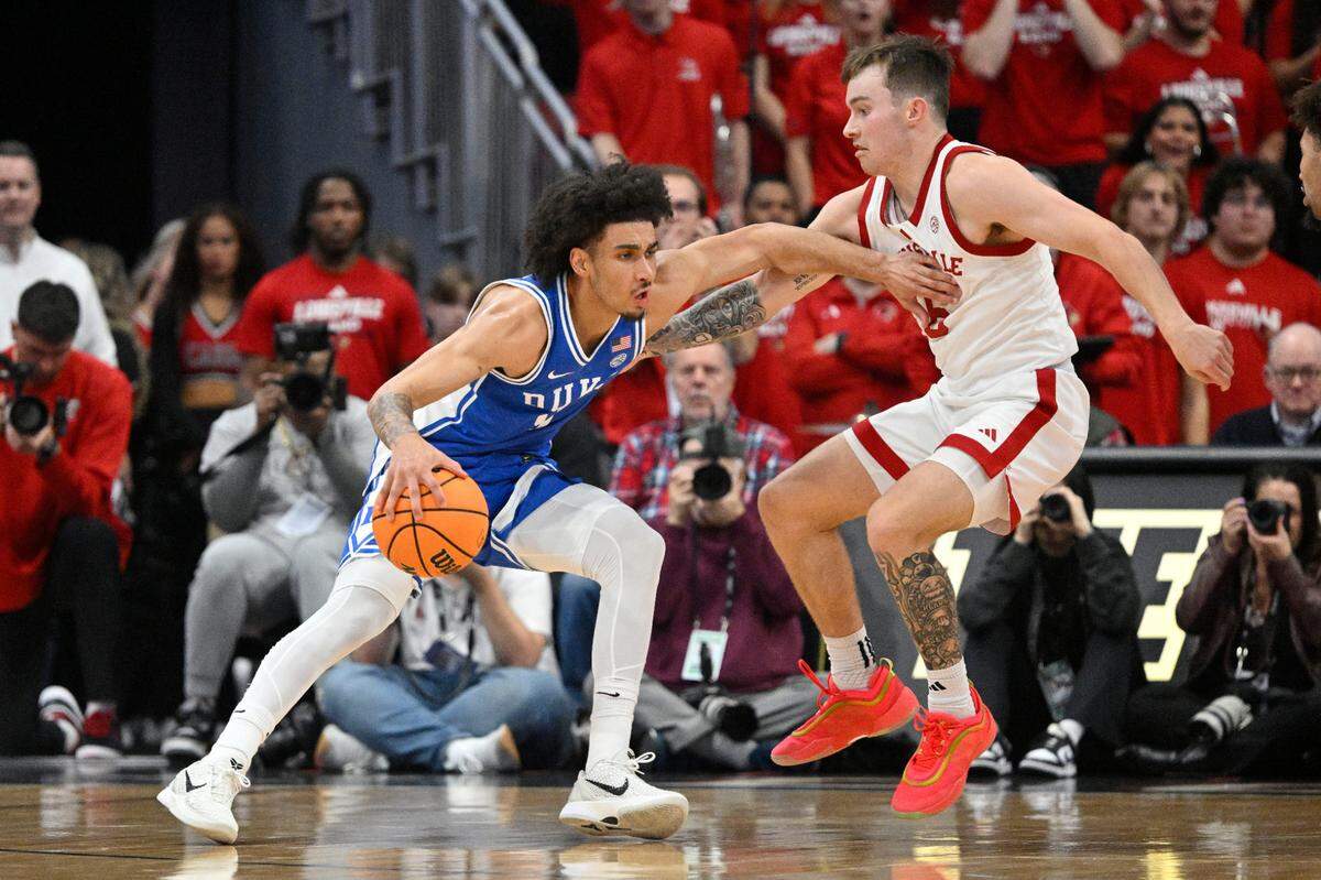 Duke Blue Devils guard Tyrese Proctor (5) dribbles against Louisville Cardinals guard Reyne Smith (6) during the second half at KFC Yum! Center on Dec. 8, 2024. Duke defeated Louisville 76-65.