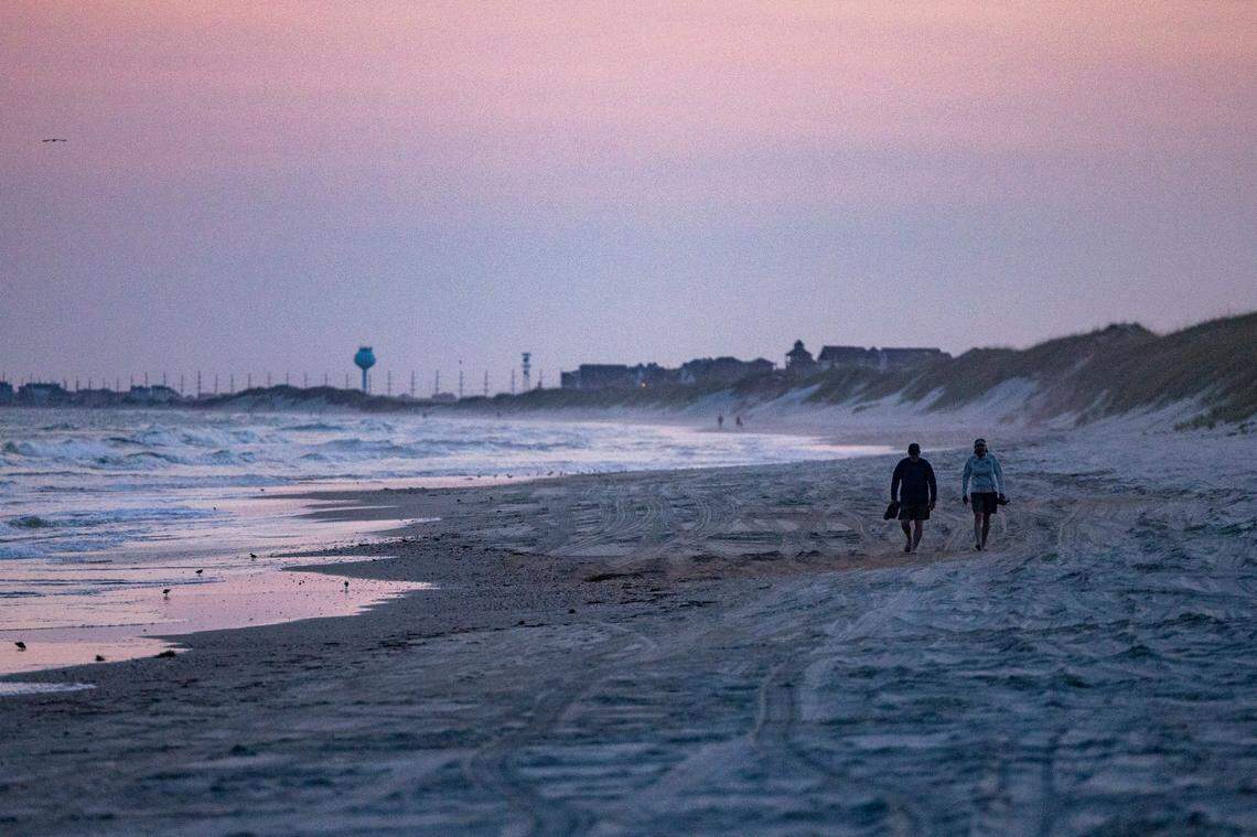 Beachgoers walk along the Cape Hatteras National Seashore in Frisco Wednesday, May 18, 2022.