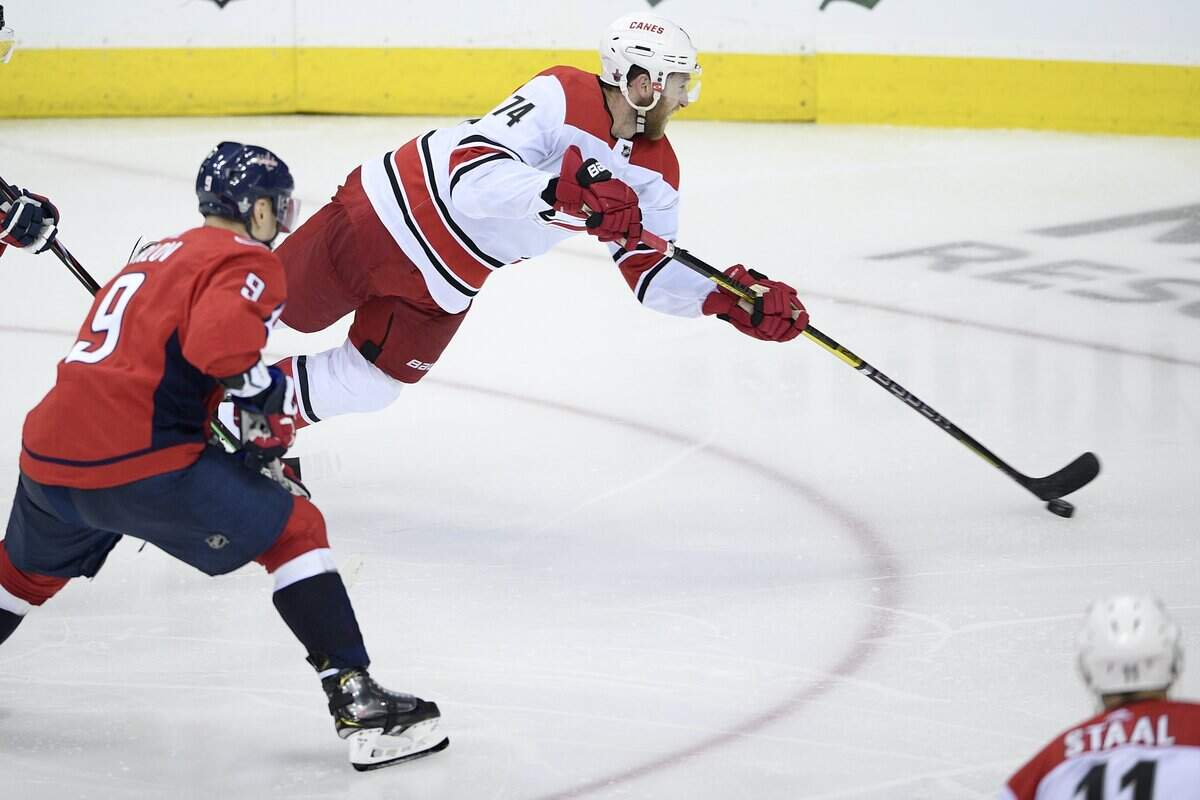Carolina Hurricanes defenseman Jaccob Slavin (74) lunges with the puck against Washington Capitals defenseman Dmitry Orlov (9), of Russia, during the third period of Game 2 of an NHL hockey first-round playoff series, Saturday, April 13, 2019, in Washington.