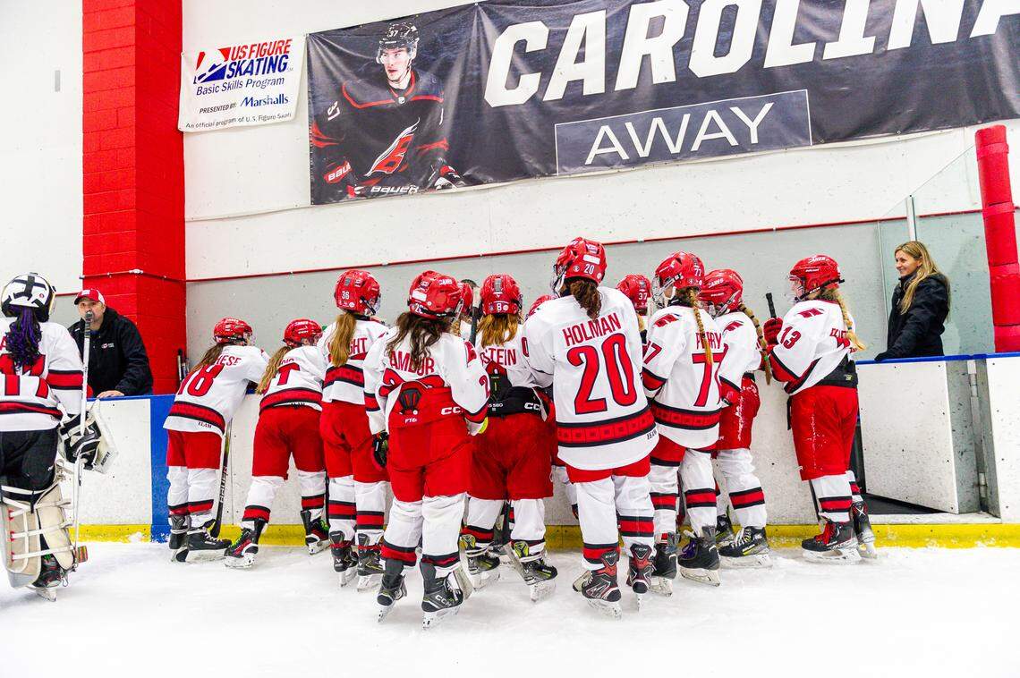 The Junior Canes Girls 10U Black team gathers at the bench before the start of a game in Winter 2025.