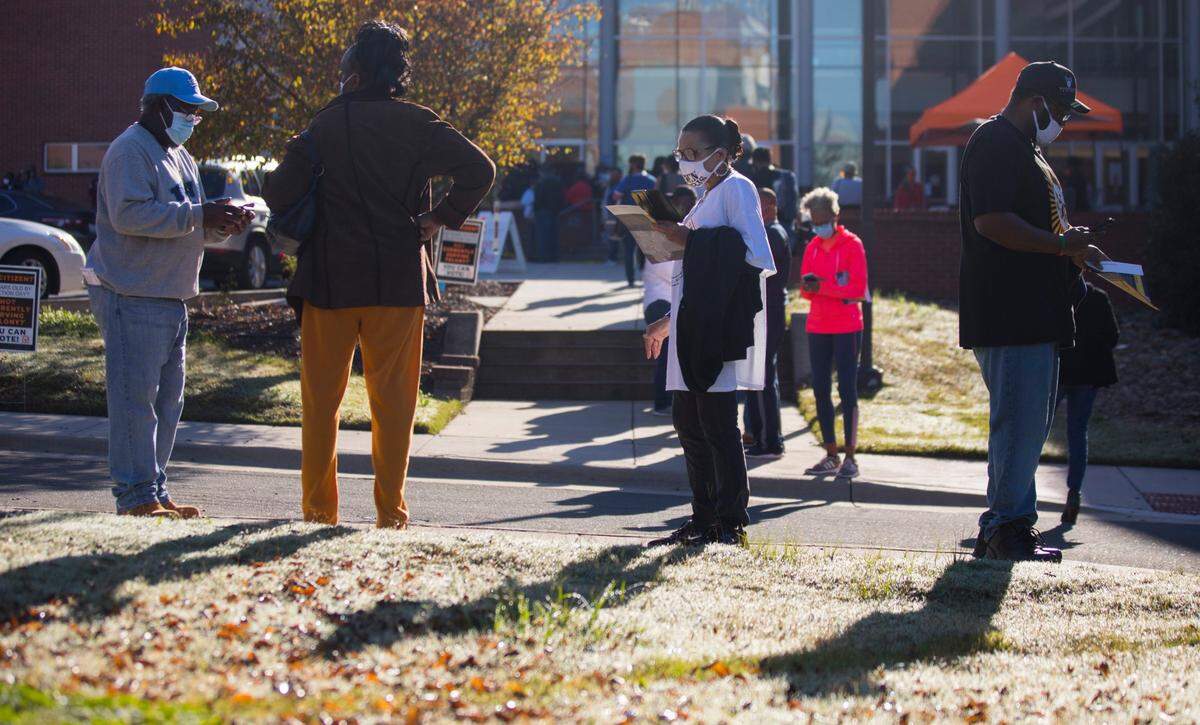 Durham County voters stand in line outside the Turner Law Building, waiting to cast their votes at N.C. Central University in Durham, N.C. on the first day of early voting, Thursday, Oct. 15, 2020.