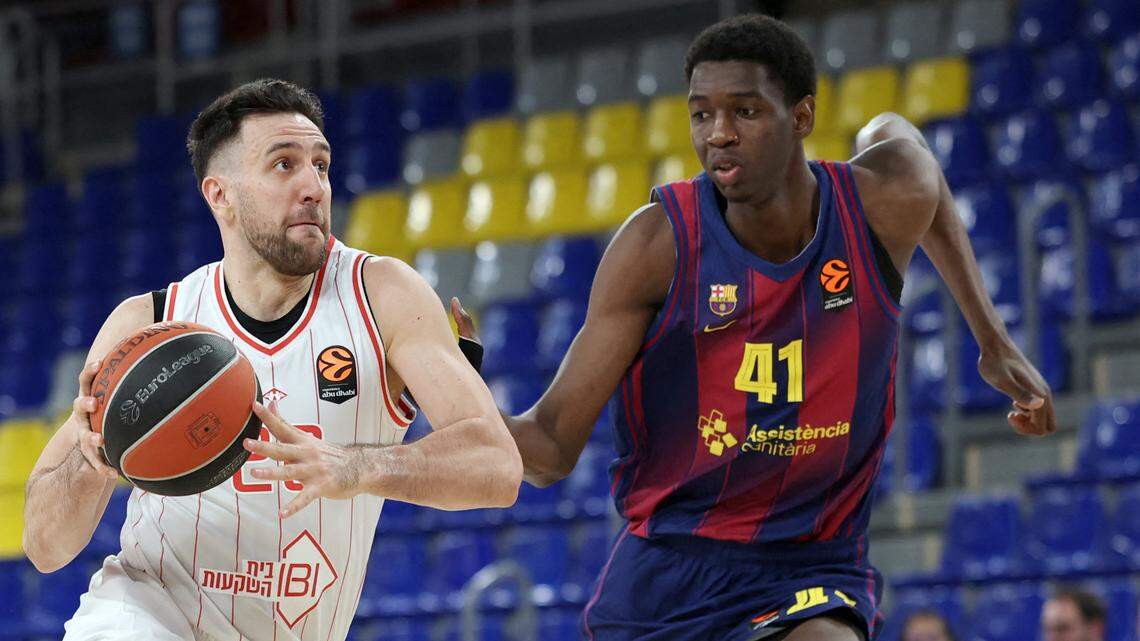Barcelona's Malian’s Sayon Keita, right, defends Hapoel IBI Tel Aviv's Vasilije Micic during the Euroleague basketball match at Palau Blaugrana arena in Barcelona on March 13, 2026.